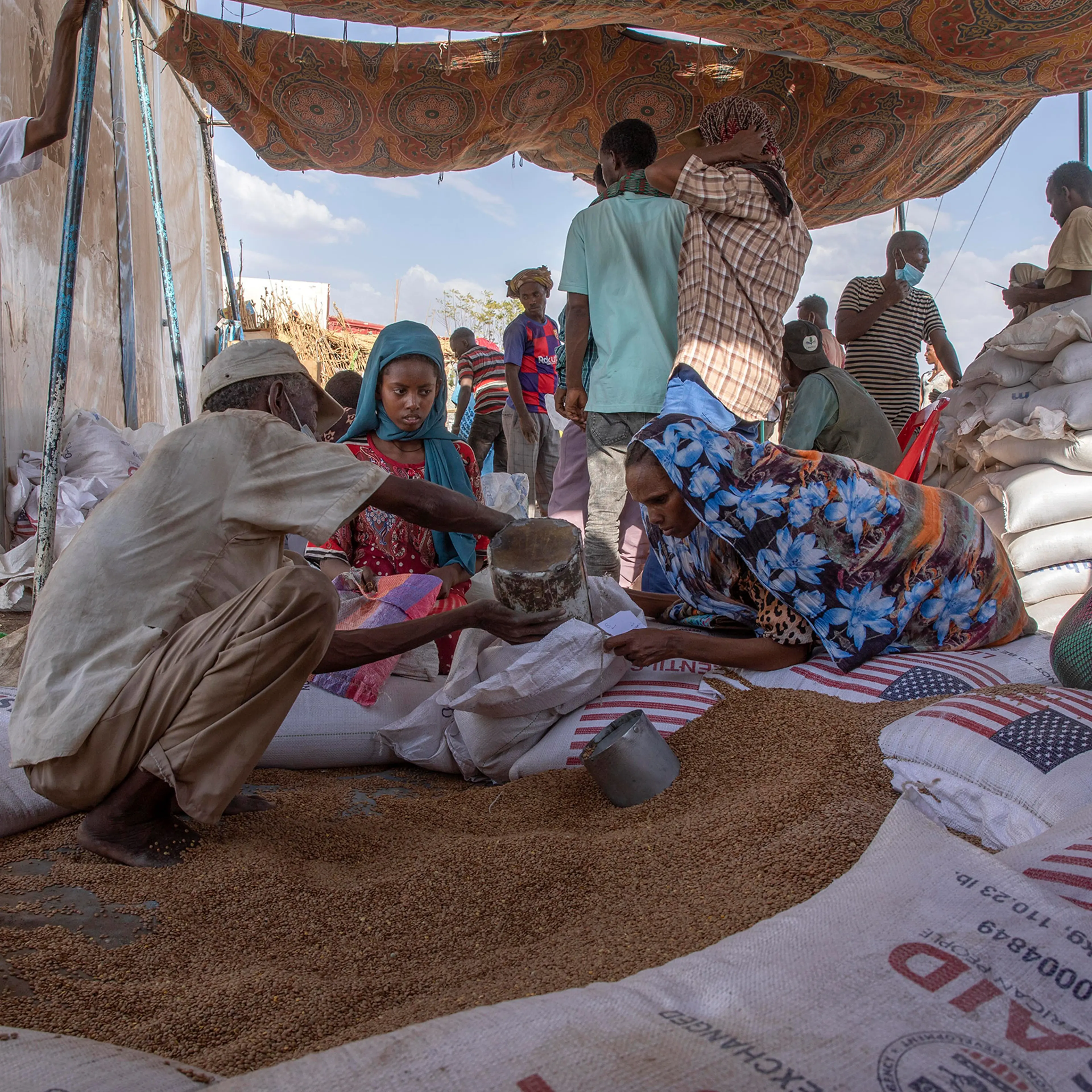 Tigrayan refugees collect food rations from USAID at Hamdeyat Transition Center near the Sudan-Ethiopia border in Eastern Sudan on Mar. 24, 2021