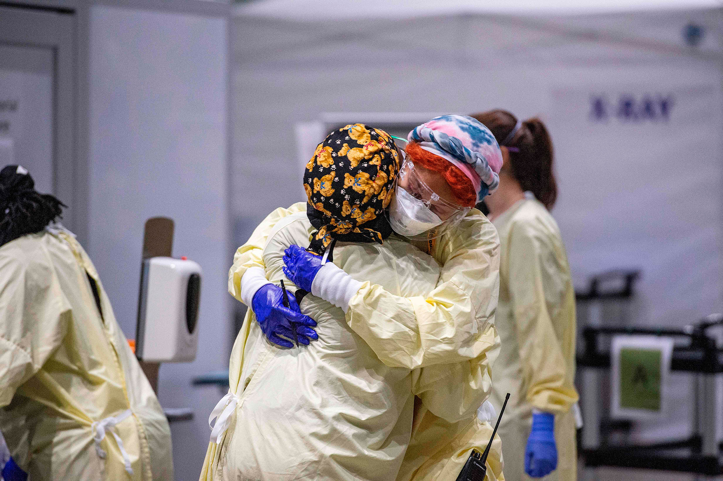 Medical worker Margaret Watkins embraces co-worker Shelly Burke as part of their morning therapy inside the hot zone where medical staff monitor and treat sick patients infected with Covid-19 at the UMASS Memorial DCU Center Field Hospital in Worcester, 
