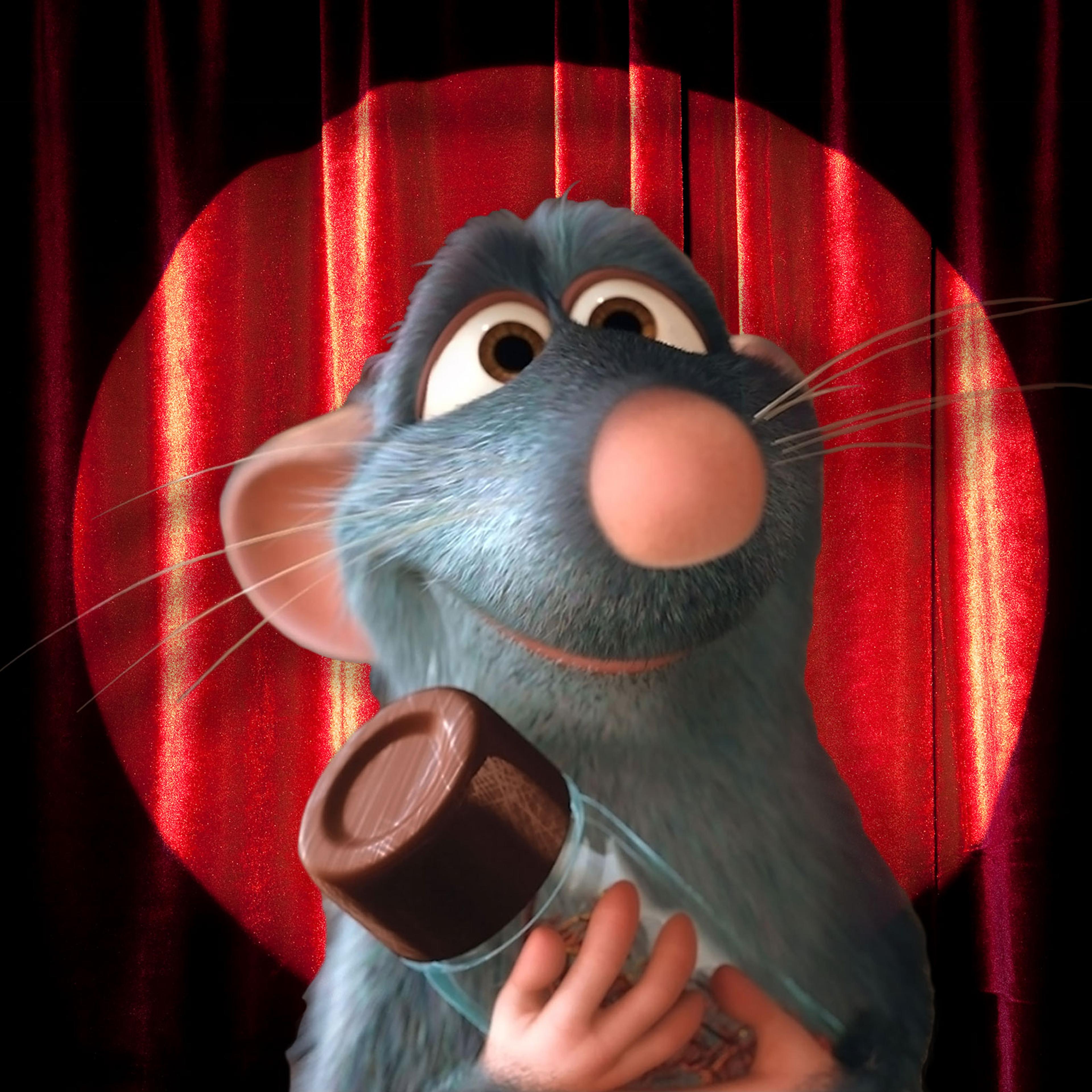 Remy from the movie Ratatouille in front of a stage screen