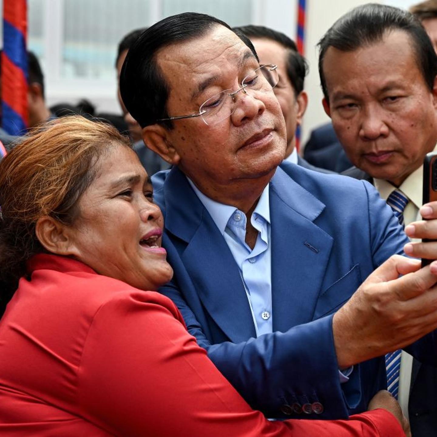 Cambodia Prime Minister Hun Sen takes a photo with a woman