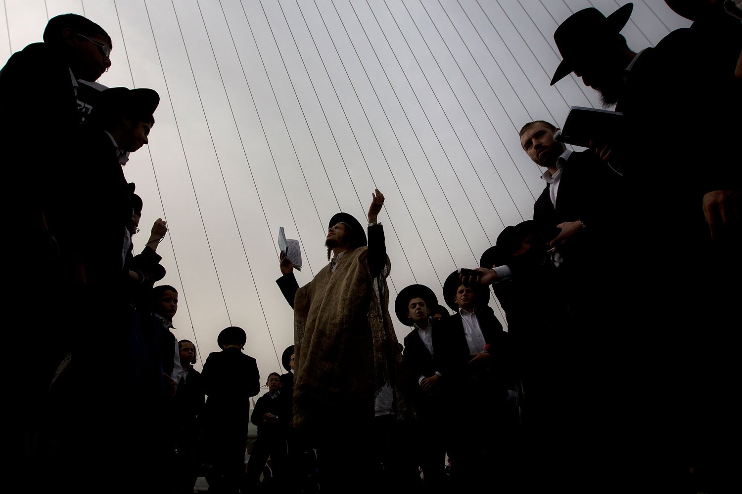 Ultra-Orthodox Jewish men pray during a rally attended by hundreds of thousands against plans to force them to serve in the Israeli military, blocking roads and paralyzing the city of Jerusalem, March 2, 2014.
