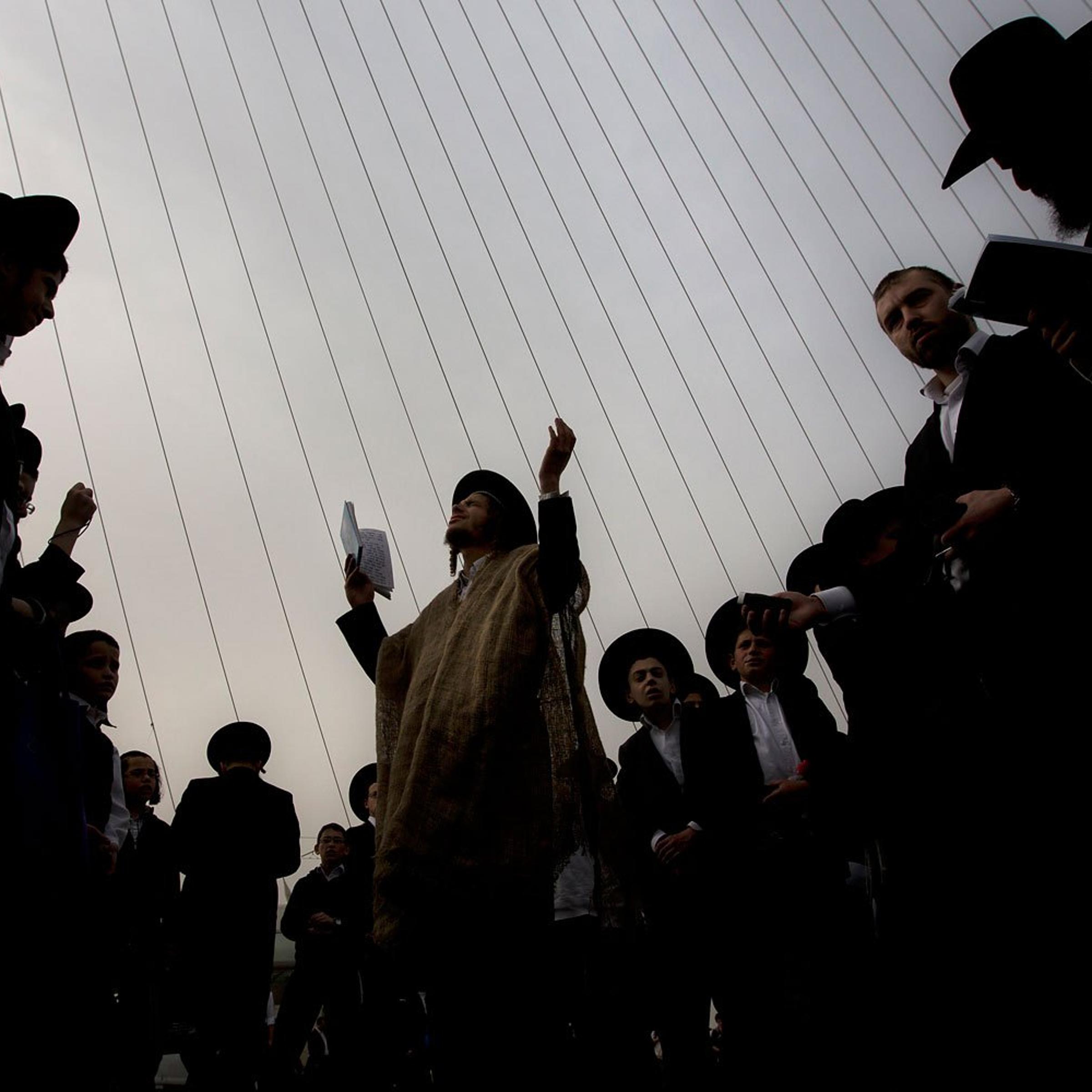 Ultra-Orthodox Jewish men pray during a rally attended by hundreds of thousands against plans to force them to serve in the Israeli military, blocking roads and paralyzing the city of Jerusalem, March 2, 2014.