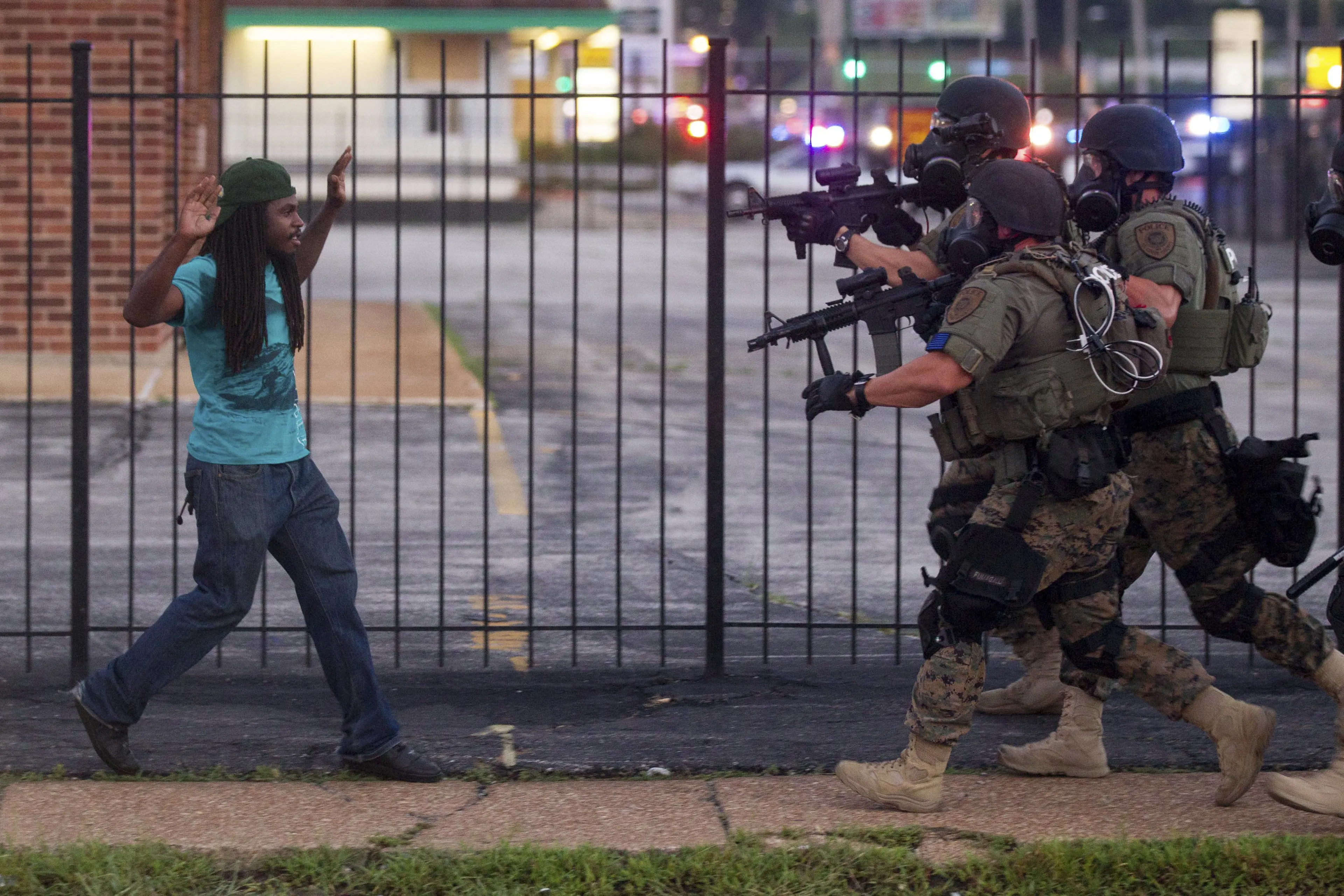 A man backs away as law enforcement officials close in on him and eventually detain him during protests over the death of Michael Brown, an unarmed black teenager killed by a police officer, in Ferguson, Mo.