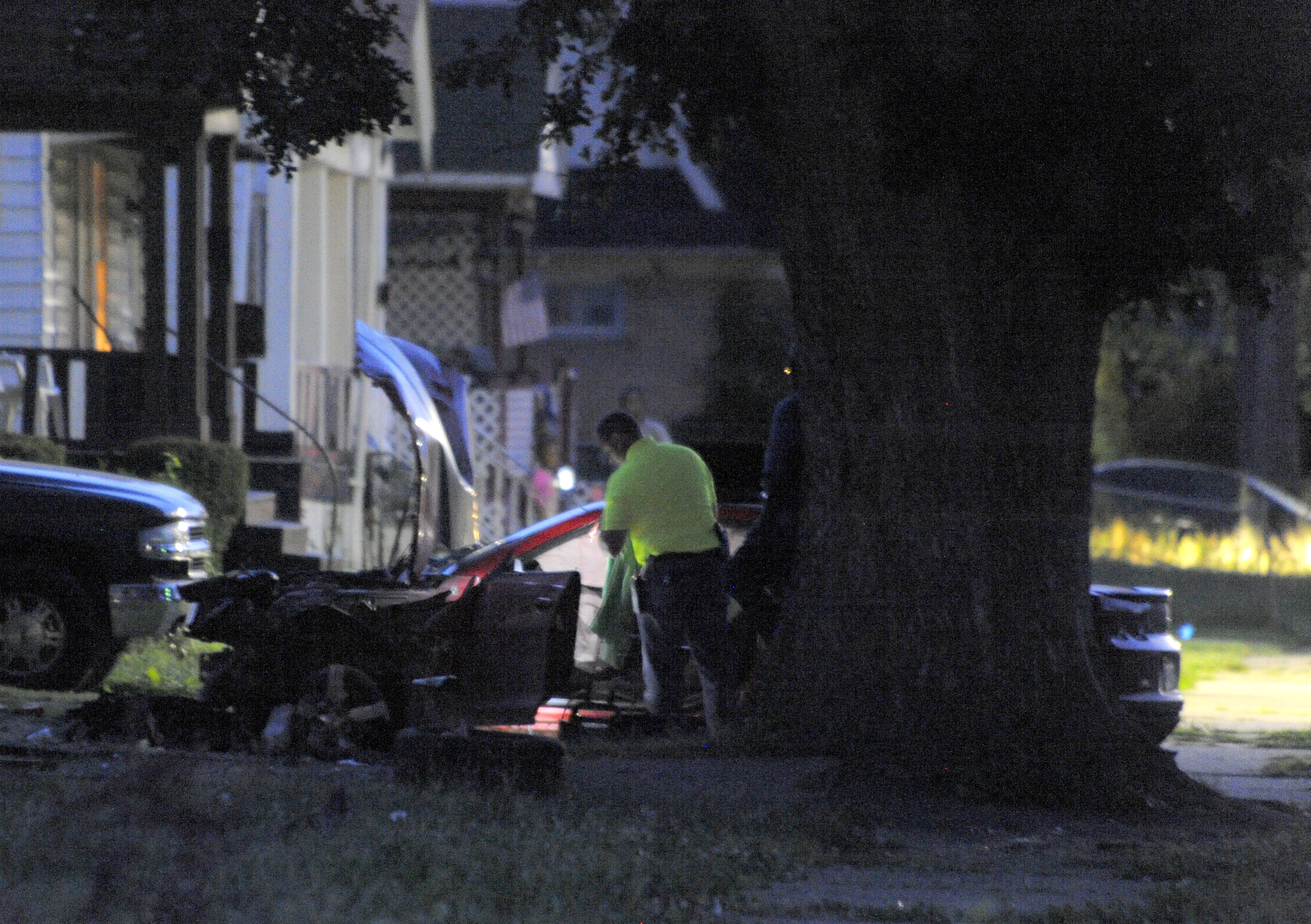 Detroit Police officers check out the damage to a car involved in a police chase on Wednesday, June 24, 2015 in Detroit.  A driver accelerated to more than 70 mph on a residential street in Detroit while fleeing officers before striking and killing two y
