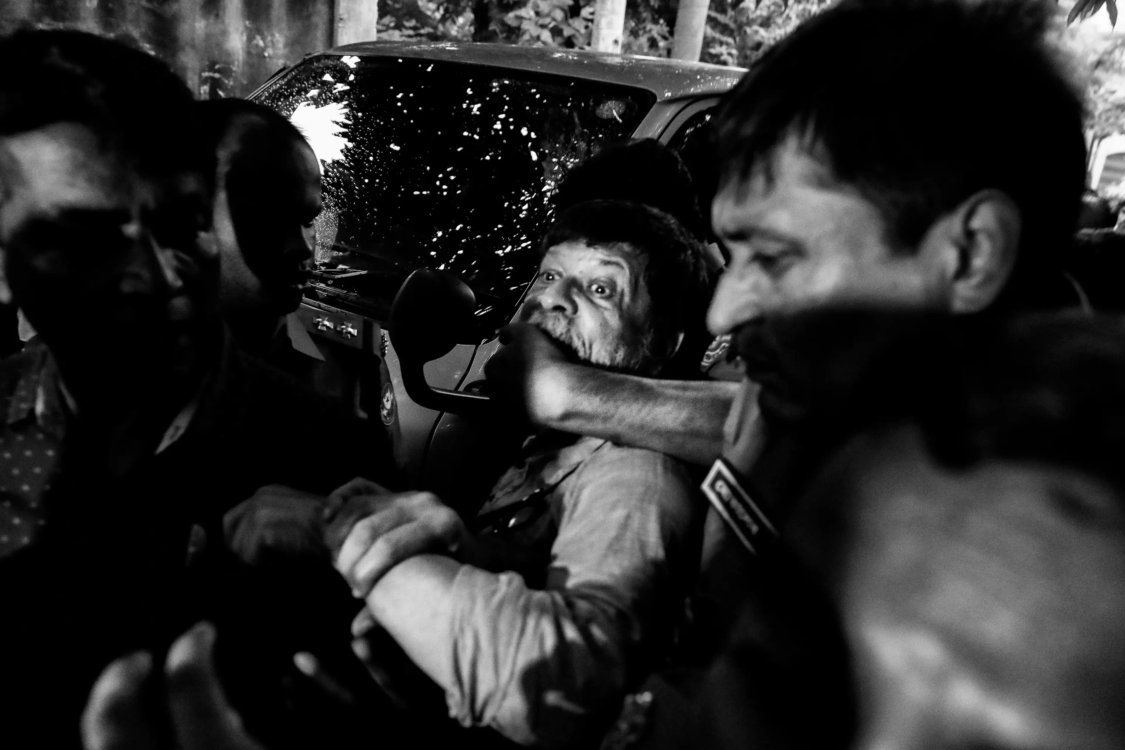 A Bangladeshi police officer grabs the mouth of photographer Shahidul Alam, preventing him from speaking to the press during a court appearance in Dhaka, Bangladesh, on Aug. 6. Alam was arrested after criticizing the government in an interview.