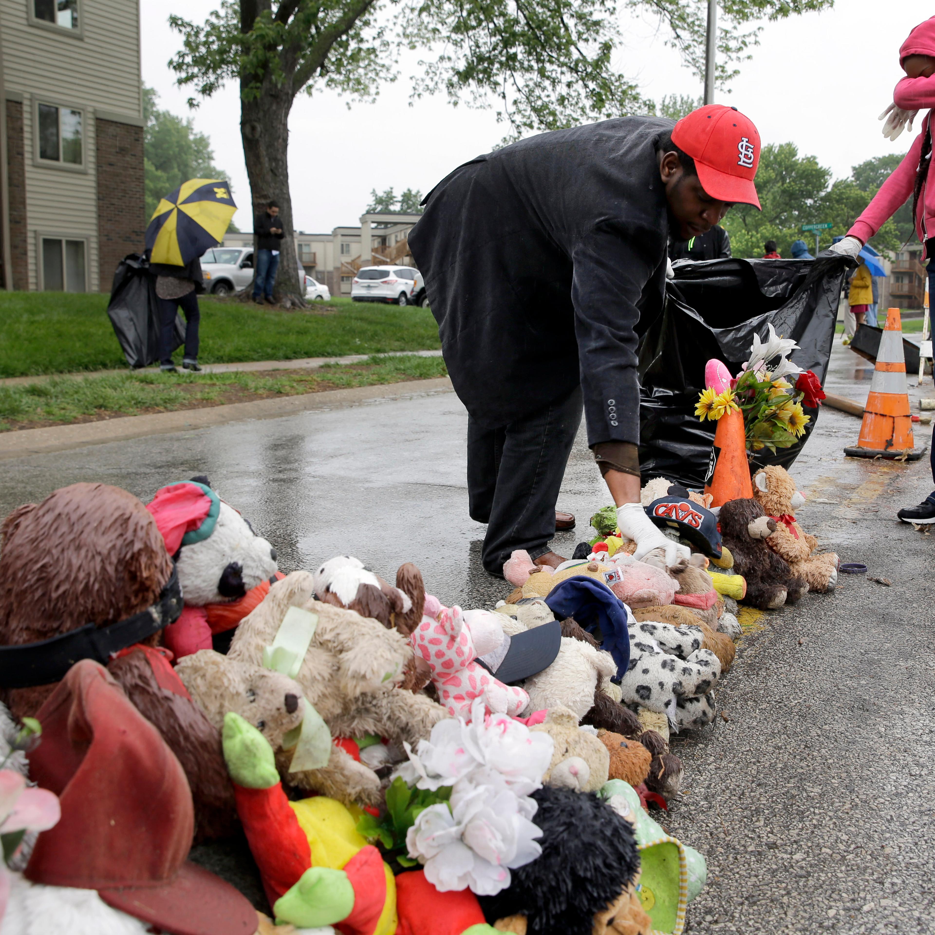 Volunteers Cheyenne Green, right, and Derrick Robinson help remove items left at a makeshift memorial to Michael Brown Wednesday, May 20, 2015, in Ferguson, Mo.