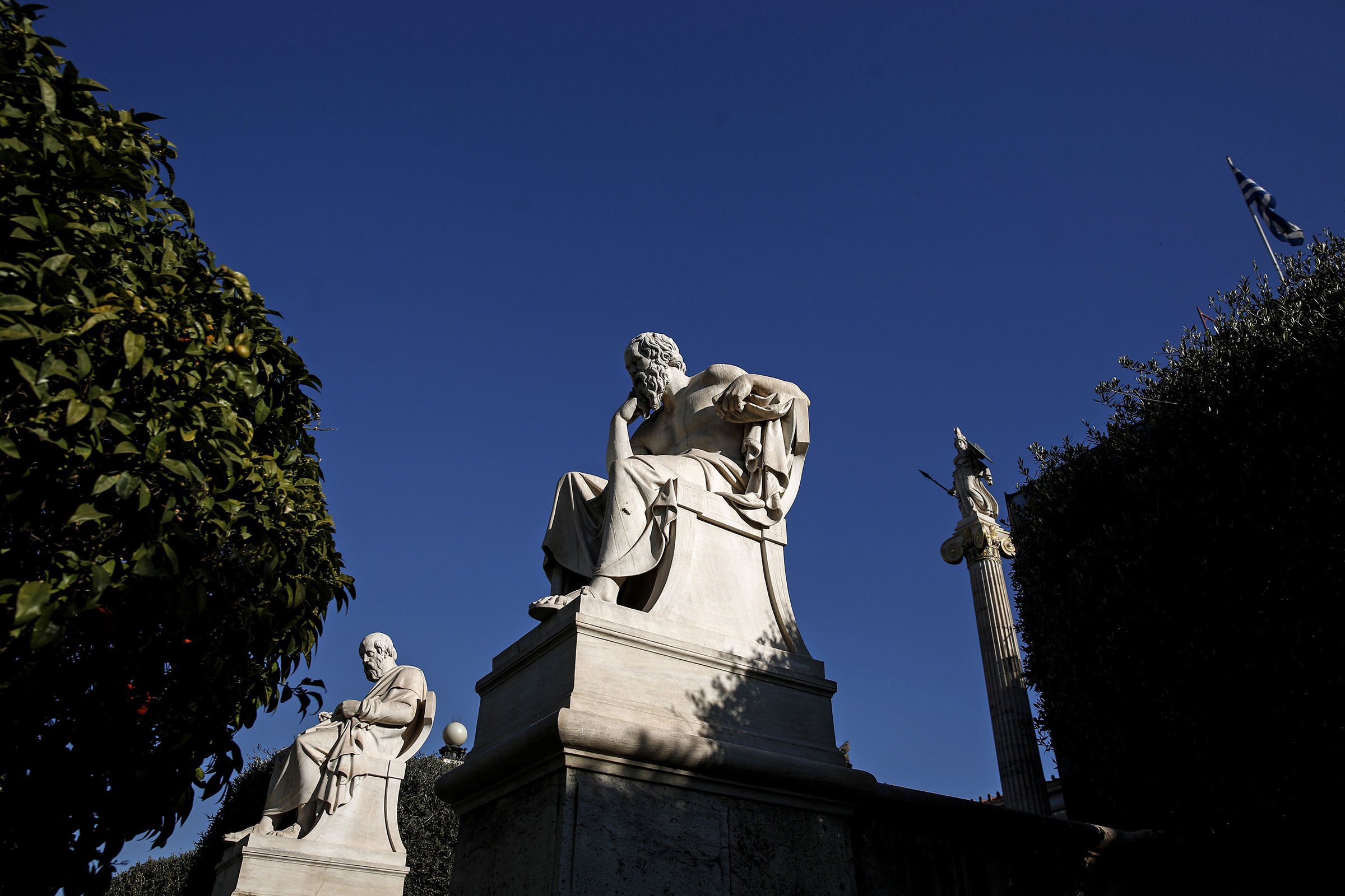 Statues of Greek philosophers Socrates, center, and Plato, sit outside the Academy of Athens, on Feb. 21, 2015.
