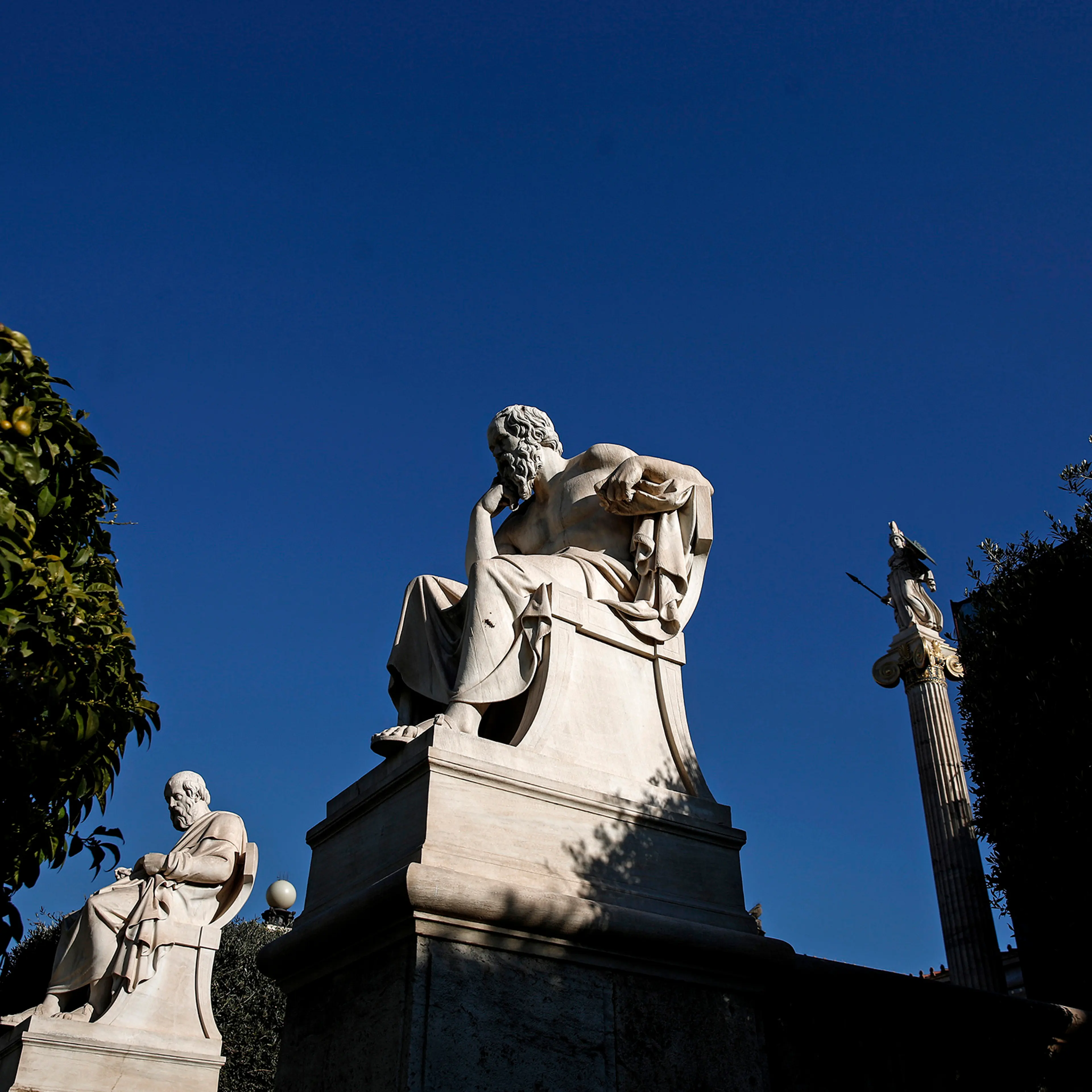 Statues of Greek philosophers Socrates, center, and Plato, sit outside the Academy of Athens, on Feb. 21, 2015.