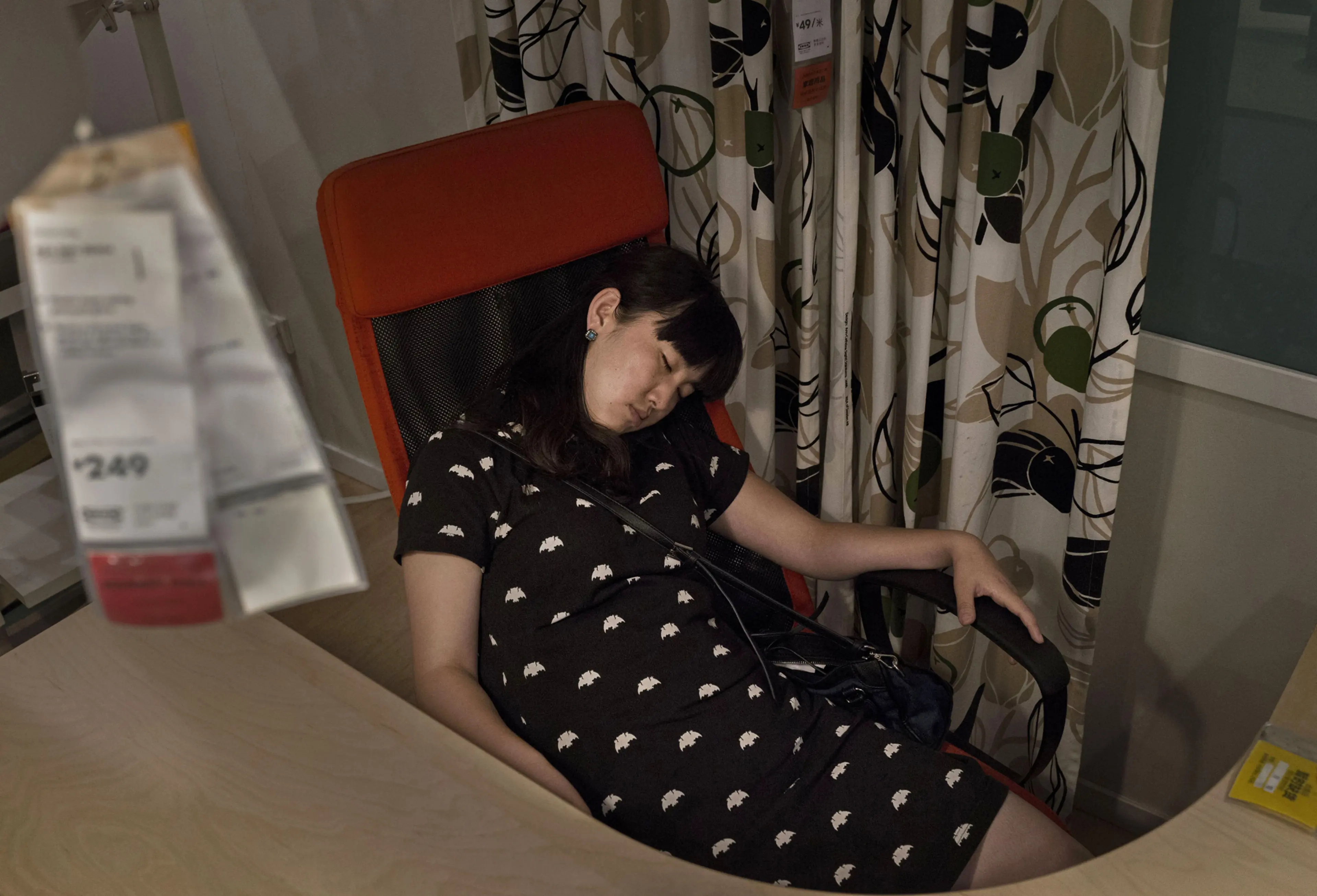 A shopper sleeps in an offfice chair in the showroom of the IKEA store on July 6, 2014 in Beijing.