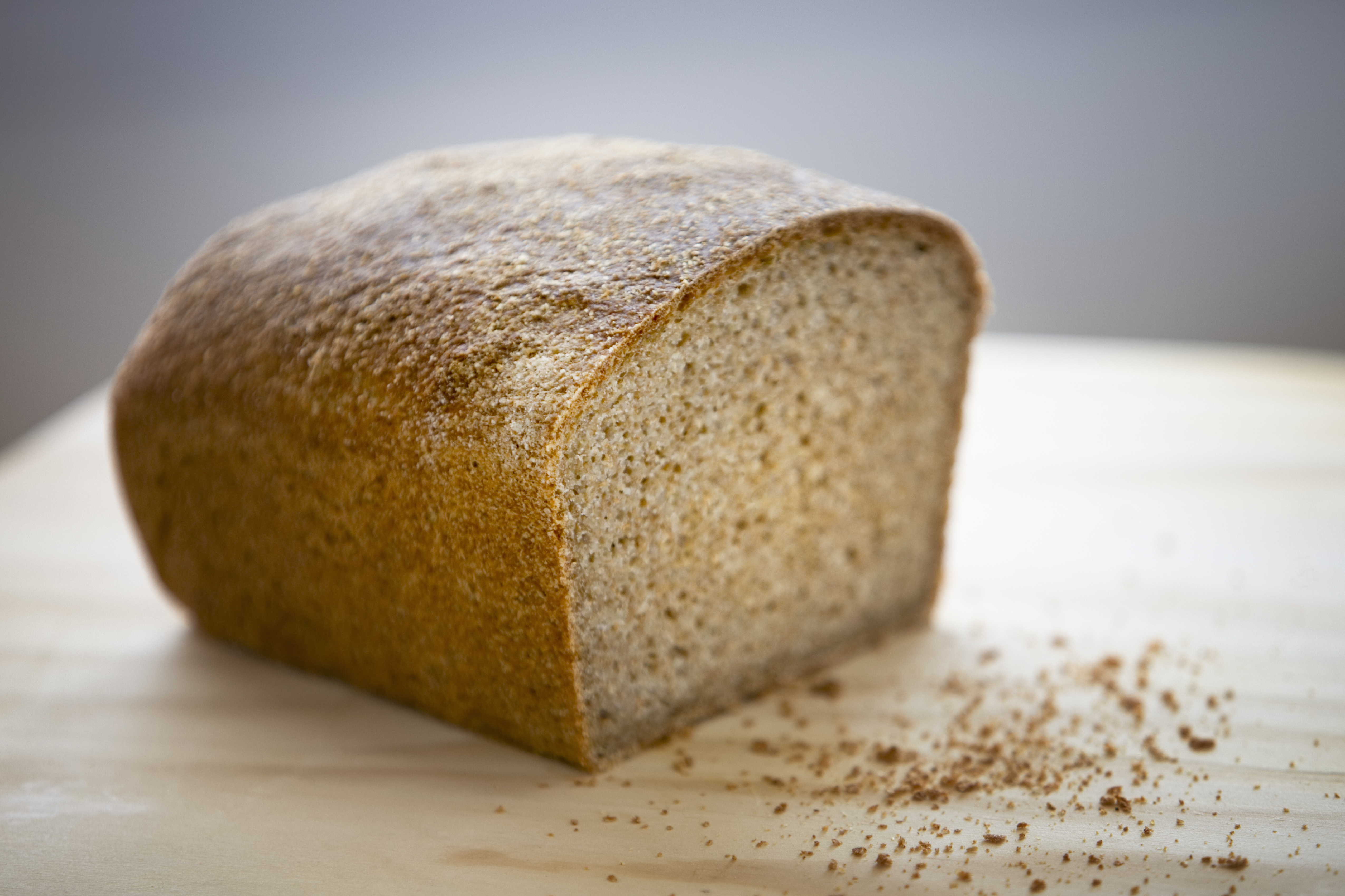 Whole wheat bread on chopping board, close-up