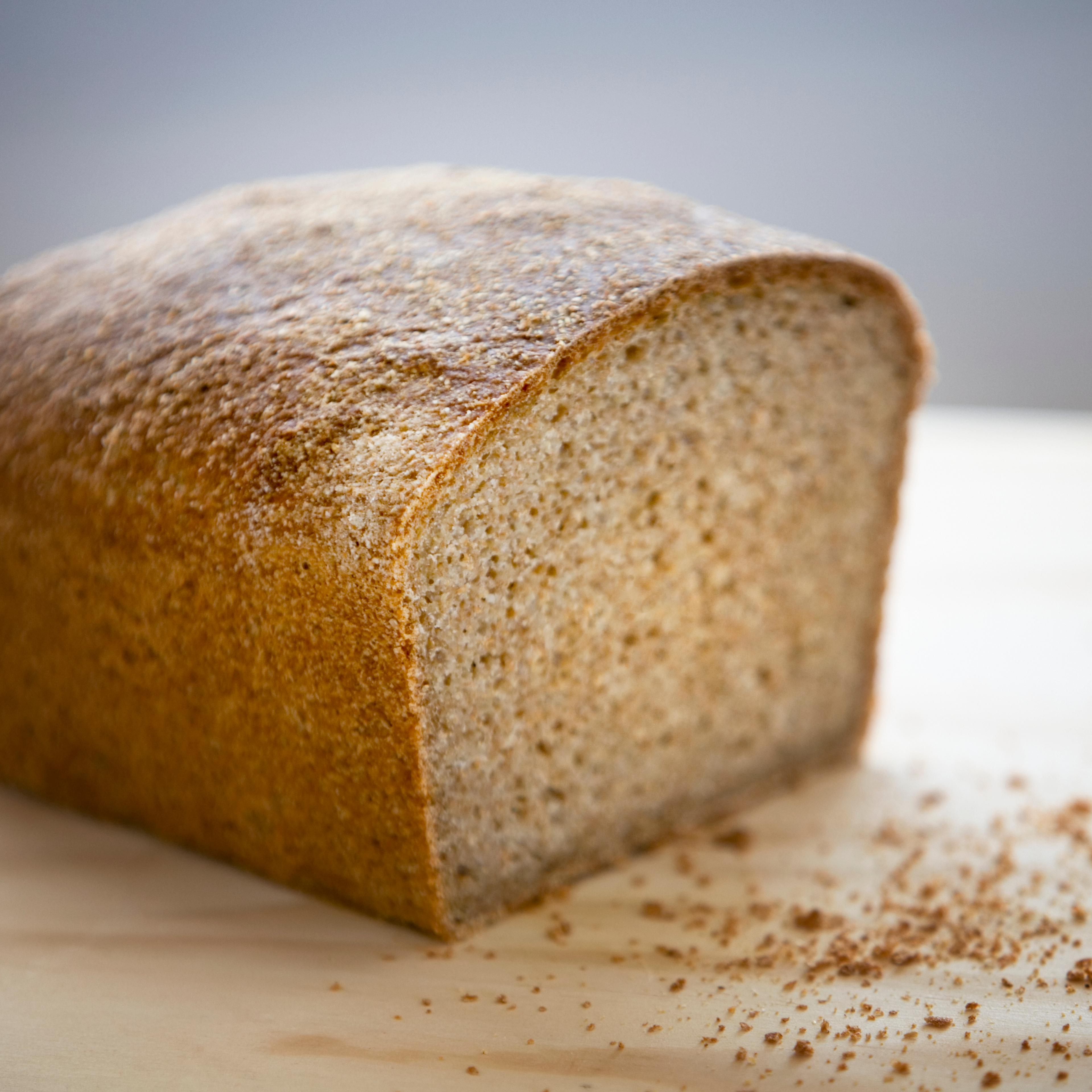 Whole wheat bread on chopping board, close-up