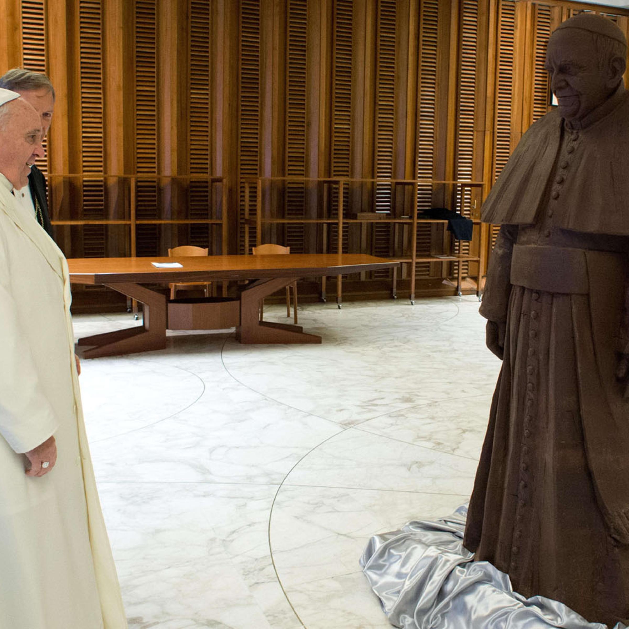 Pope Francis looks at a chocolate statue of himself, given to him after his weekly audience, on Feb. 5, 2014.