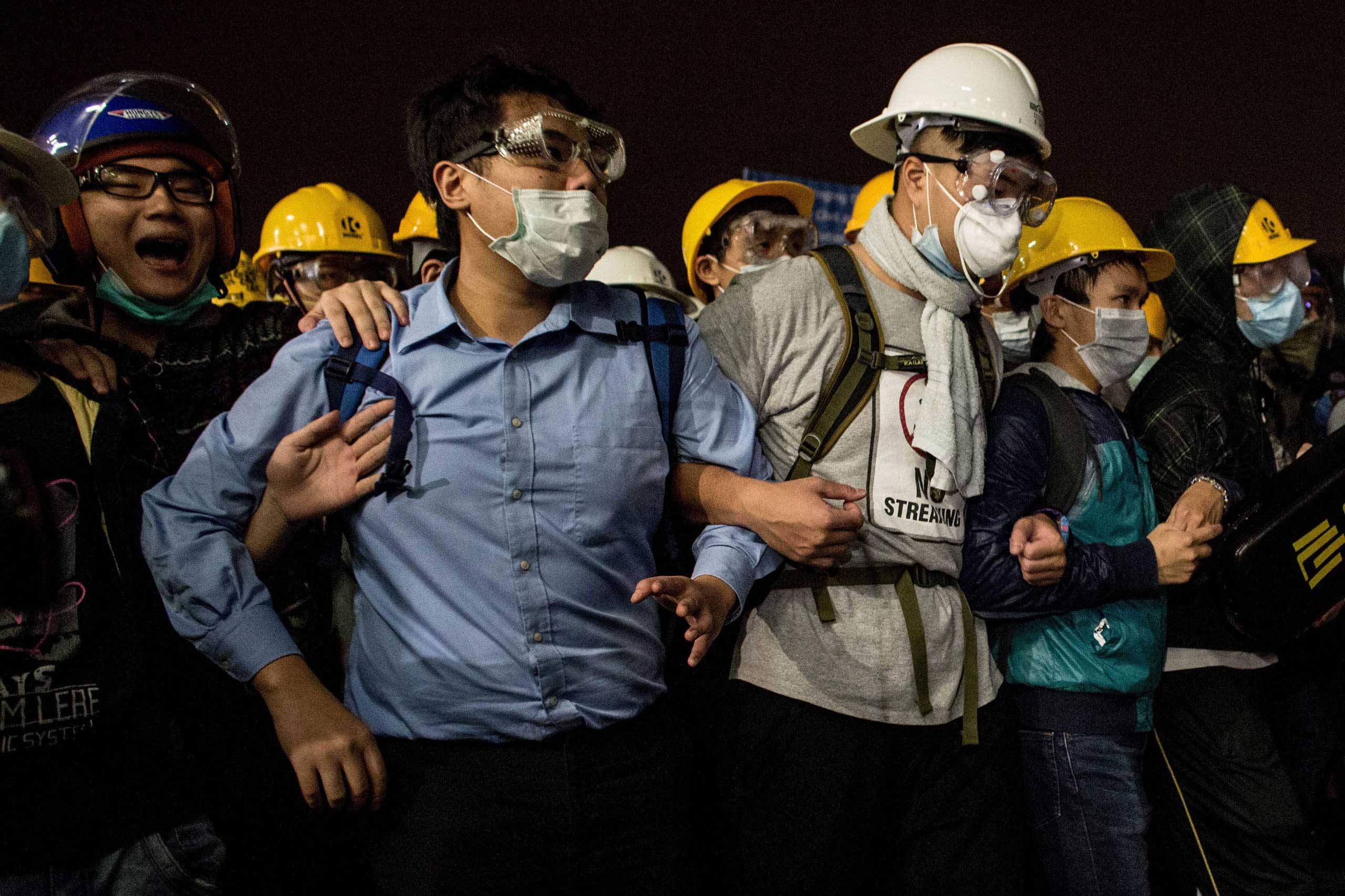 Pro-democracy activists join arms as they face off with police outside the Legislative Council building on Nov. 19, 2014 in Hong Kong.