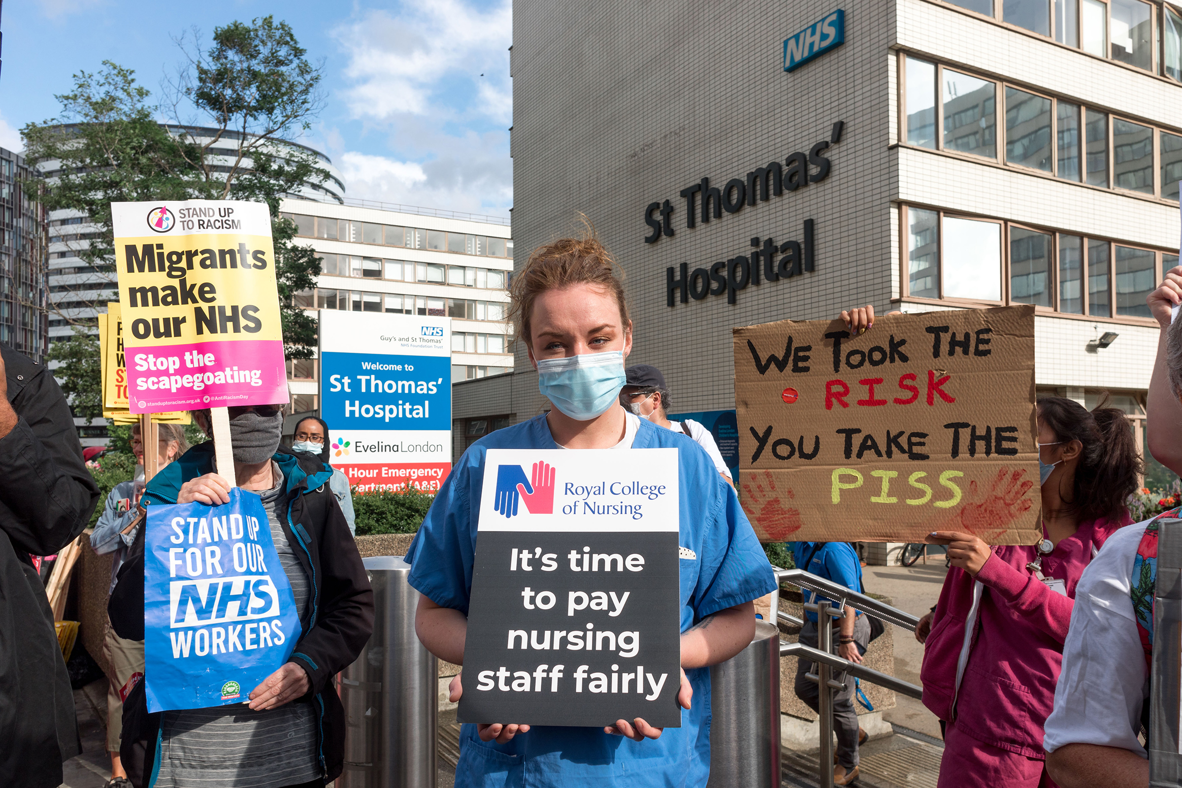 A protestor holds a placard that says "It's time to pay nursing staff fairly" outside St. Thomas' Hospital in London on July 30, 2020.