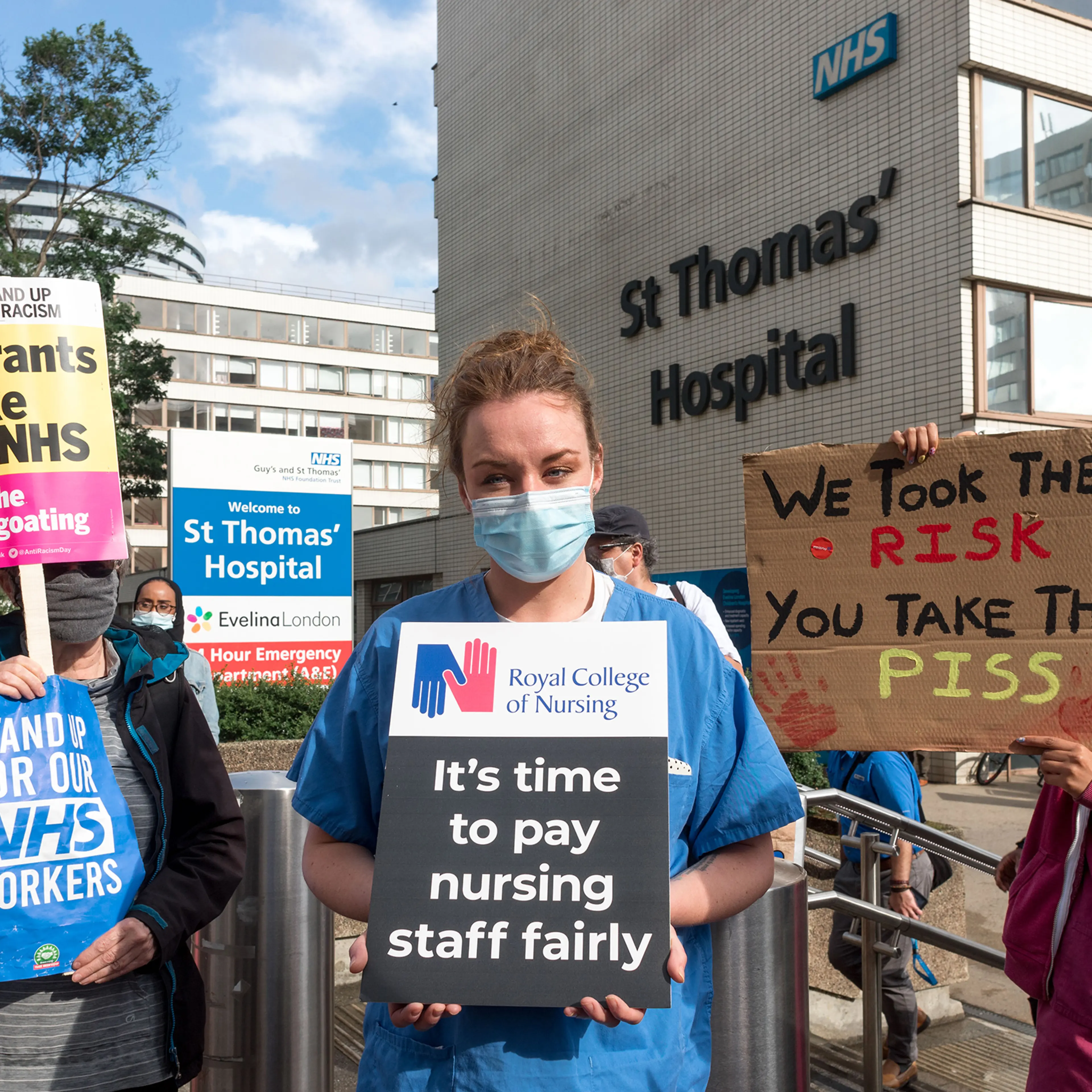 A protestor holds a placard that says "It's time to pay nursing staff fairly" outside St. Thomas' Hospital in London on July 30, 2020.