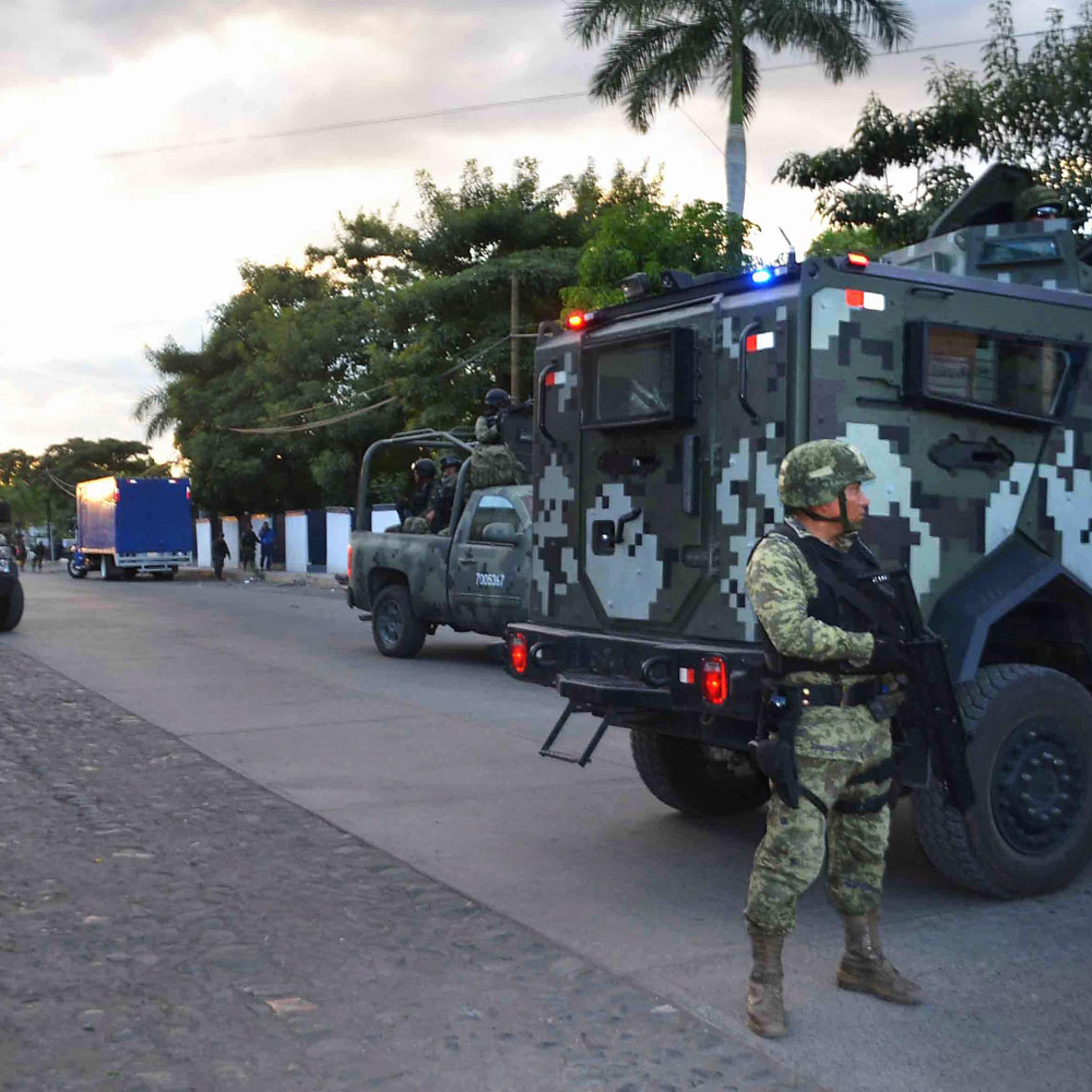 Military personnel and federal policemen guard an area where the dead body of Mexican drug lord Nazario 'El Chayo' Moreno Gonzalez remains, in Apatzingan, Mexico, March 9, 2014.