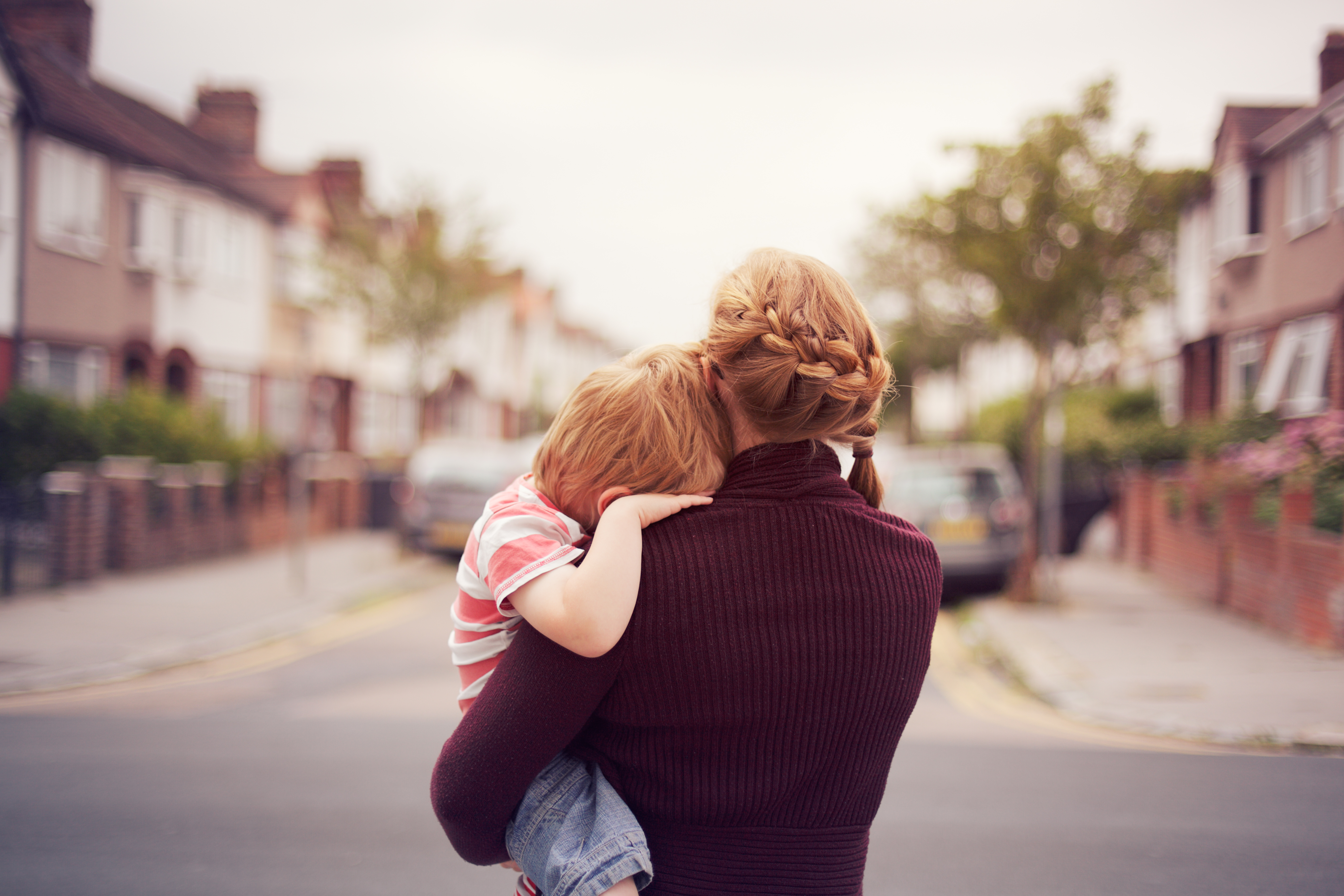 Young boy resting on mother's shoulder