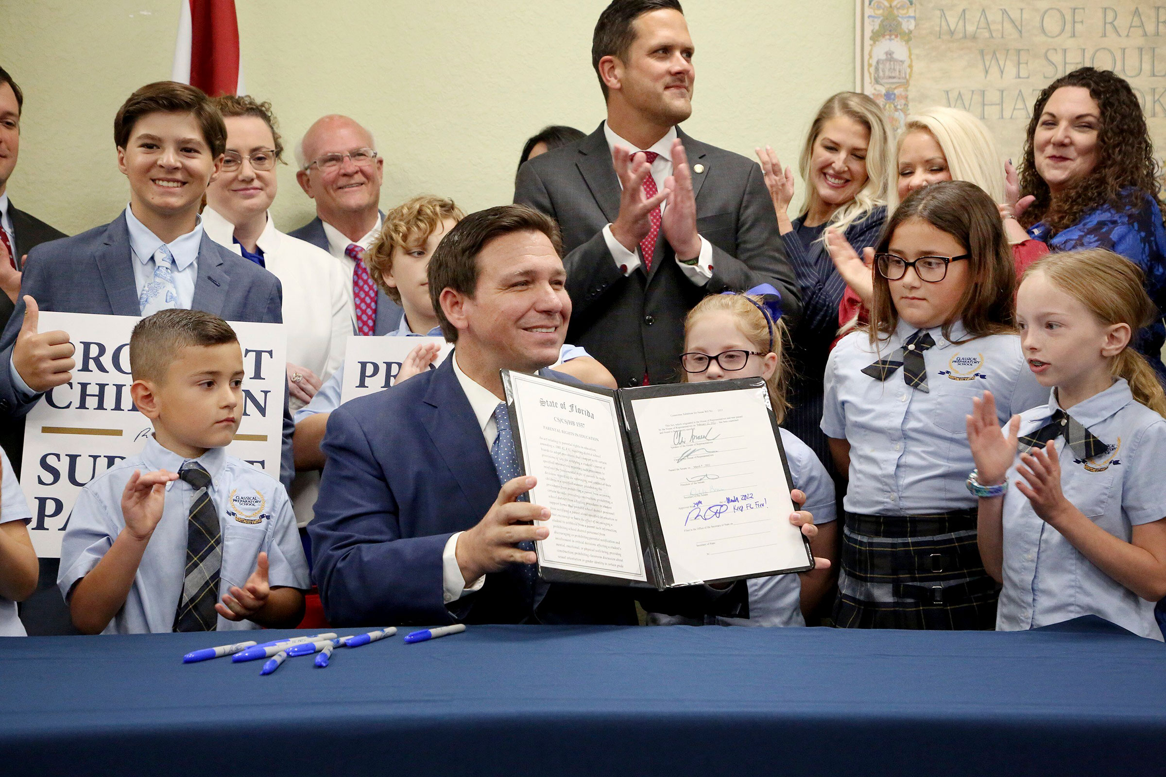 Florida Gov. Ron DeSantis displays the signed Parental Rights in Education, aka the Don't Say Gay bill, flanked by elementary school students during a news conference at Classical Preparatory school in Shady Hills, Fla. on March 28, 2022.