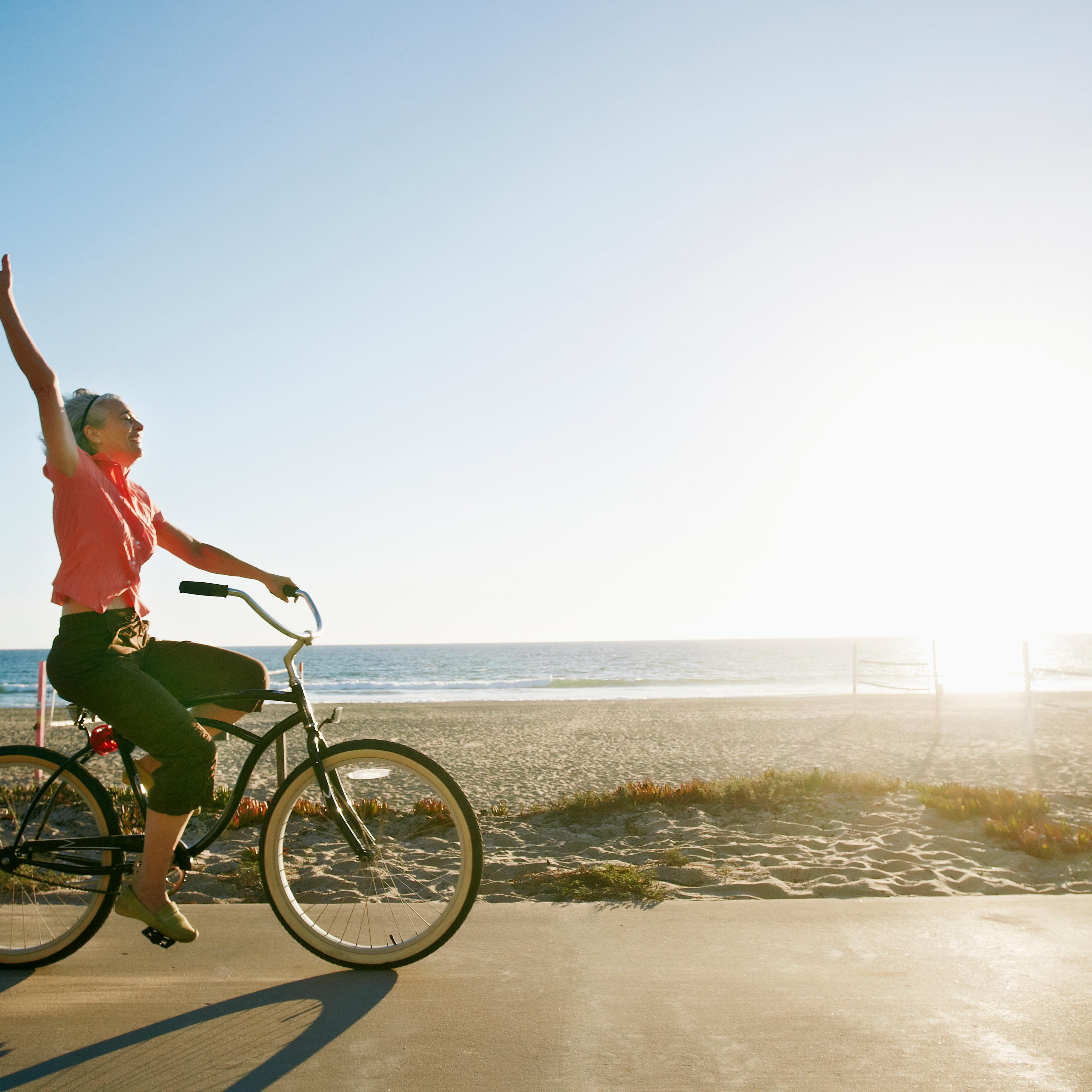 Caucasian woman riding bicycle near beach