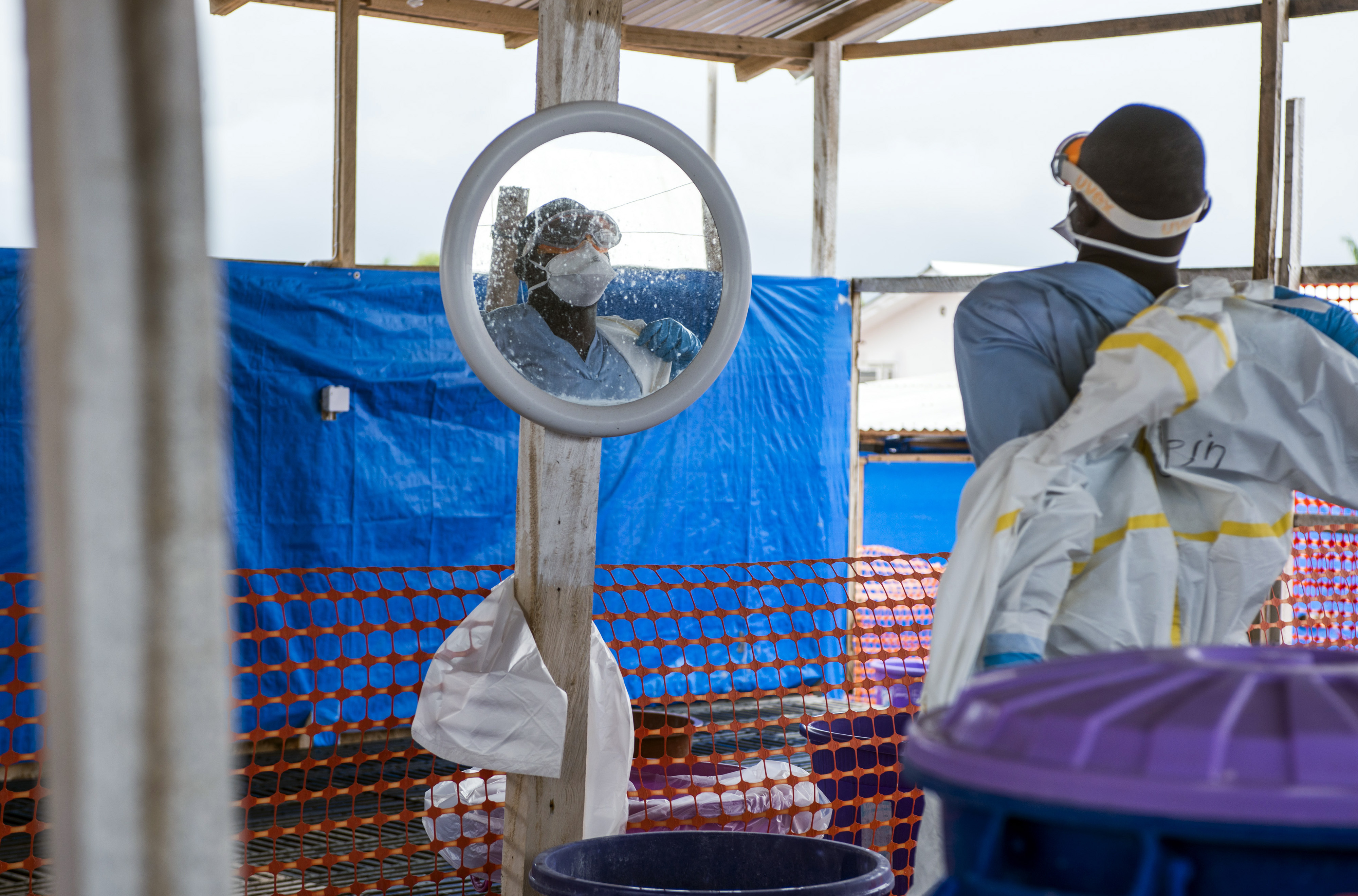 A healthcare worker removes his protective equipment at an Ebola treatment center in Coyah, Guinea, on Thursday, Sept. 10, 2015