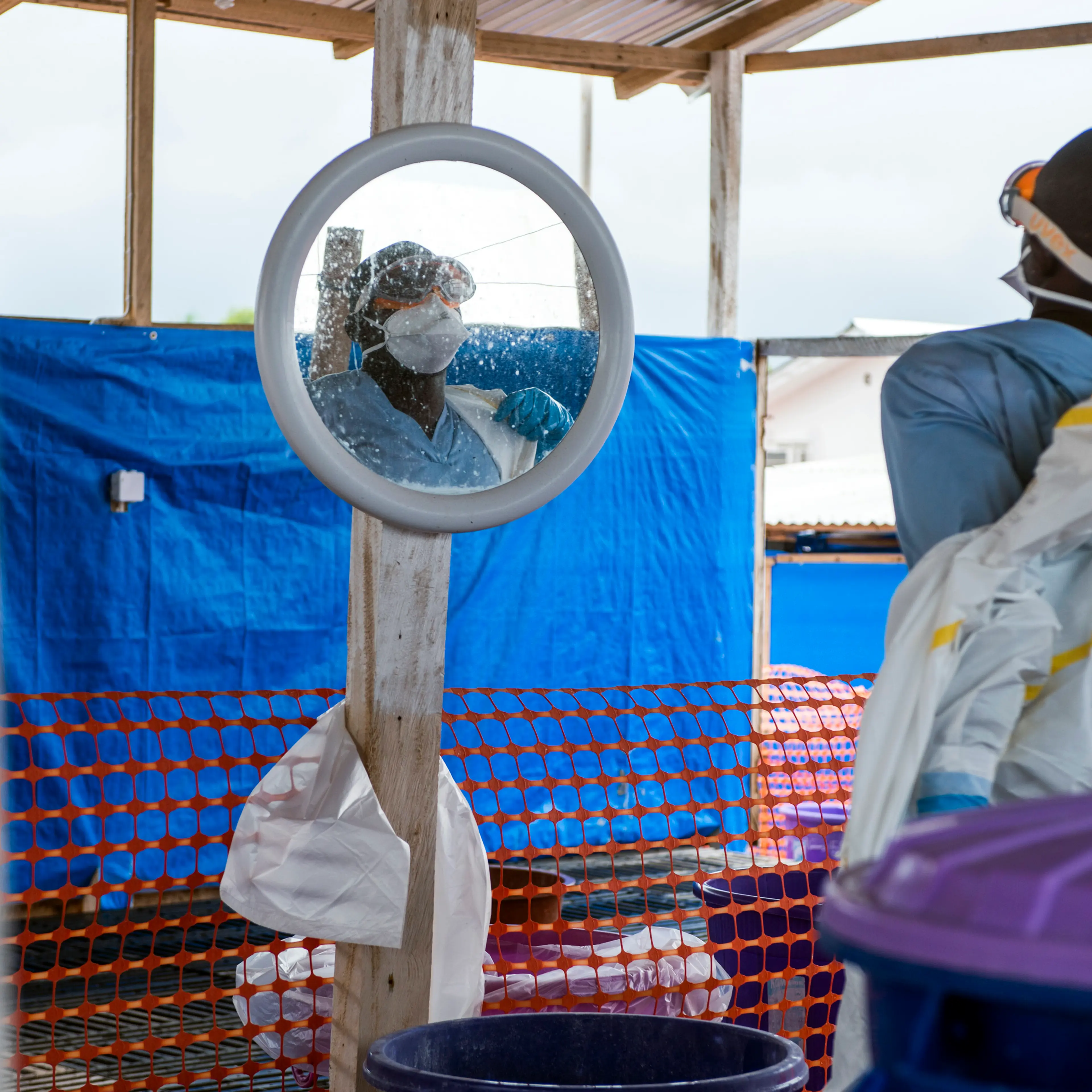 A healthcare worker removes his protective equipment at an Ebola treatment center in Coyah, Guinea, on Thursday, Sept. 10, 2015