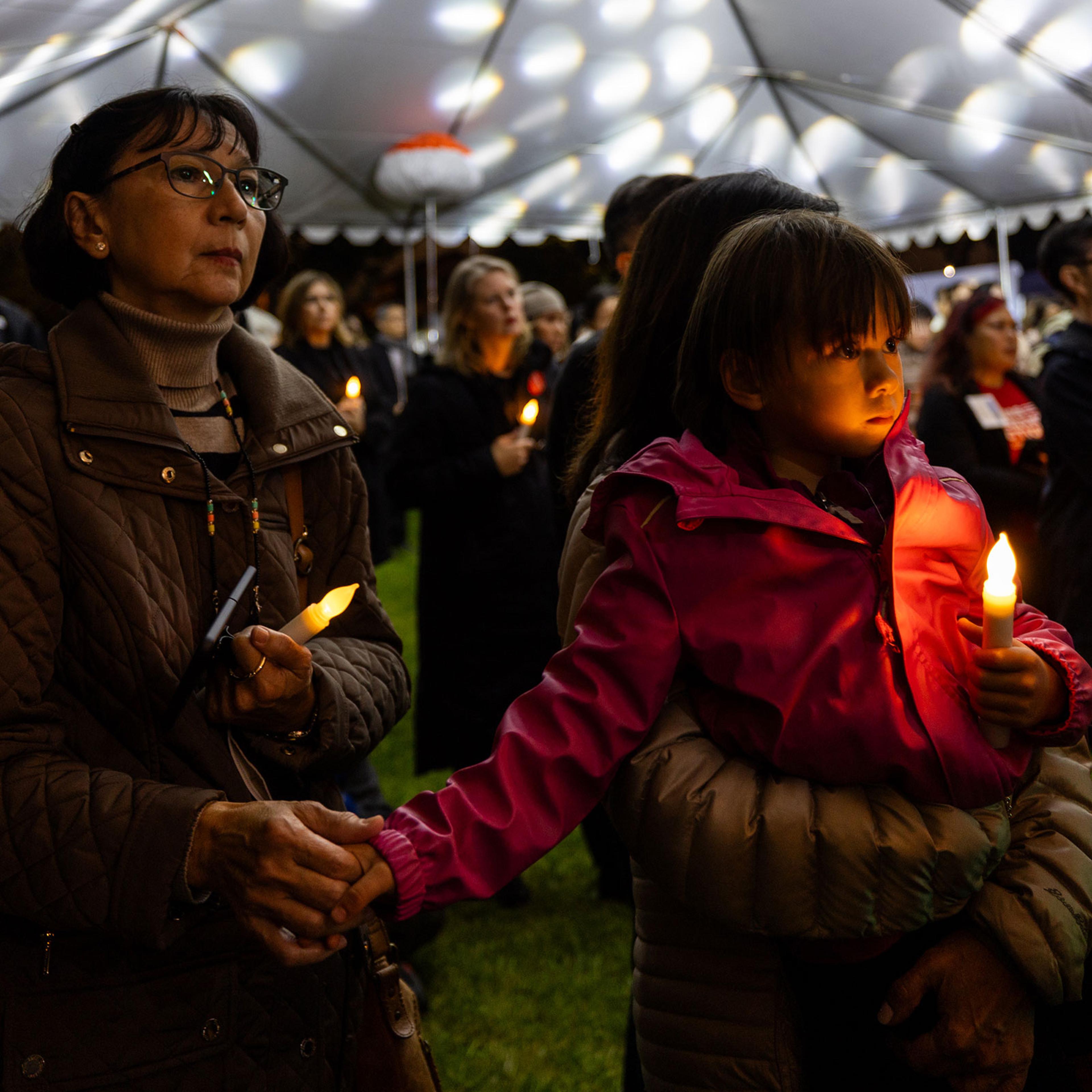 Mourners hold candles during a candlelight vigil to commemorate the first anniversary of a mass shooting in Monterey Park in Los Angeles on Jan. 21, 2024.