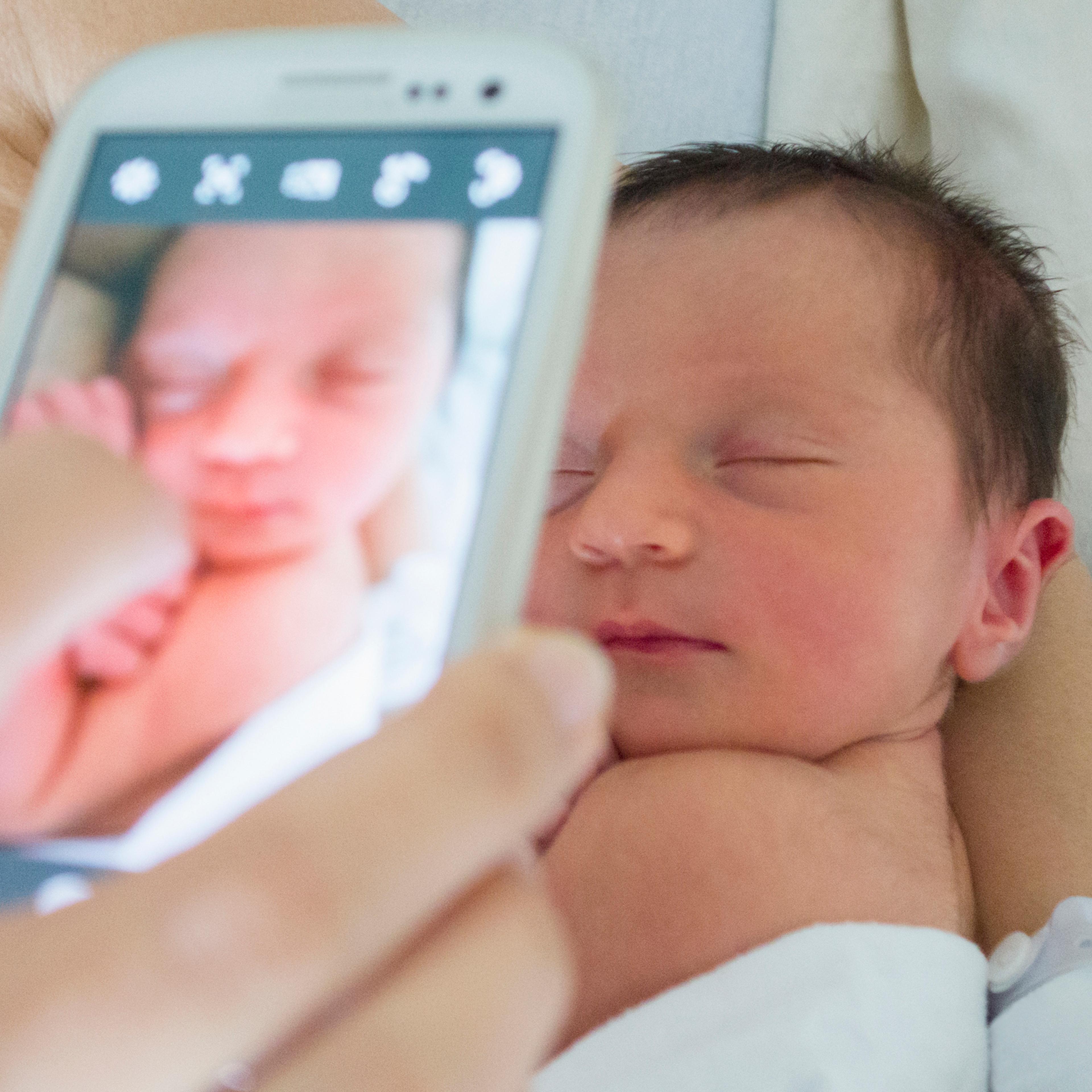 USA, New York, New York City, Mother photographing newborn daughter