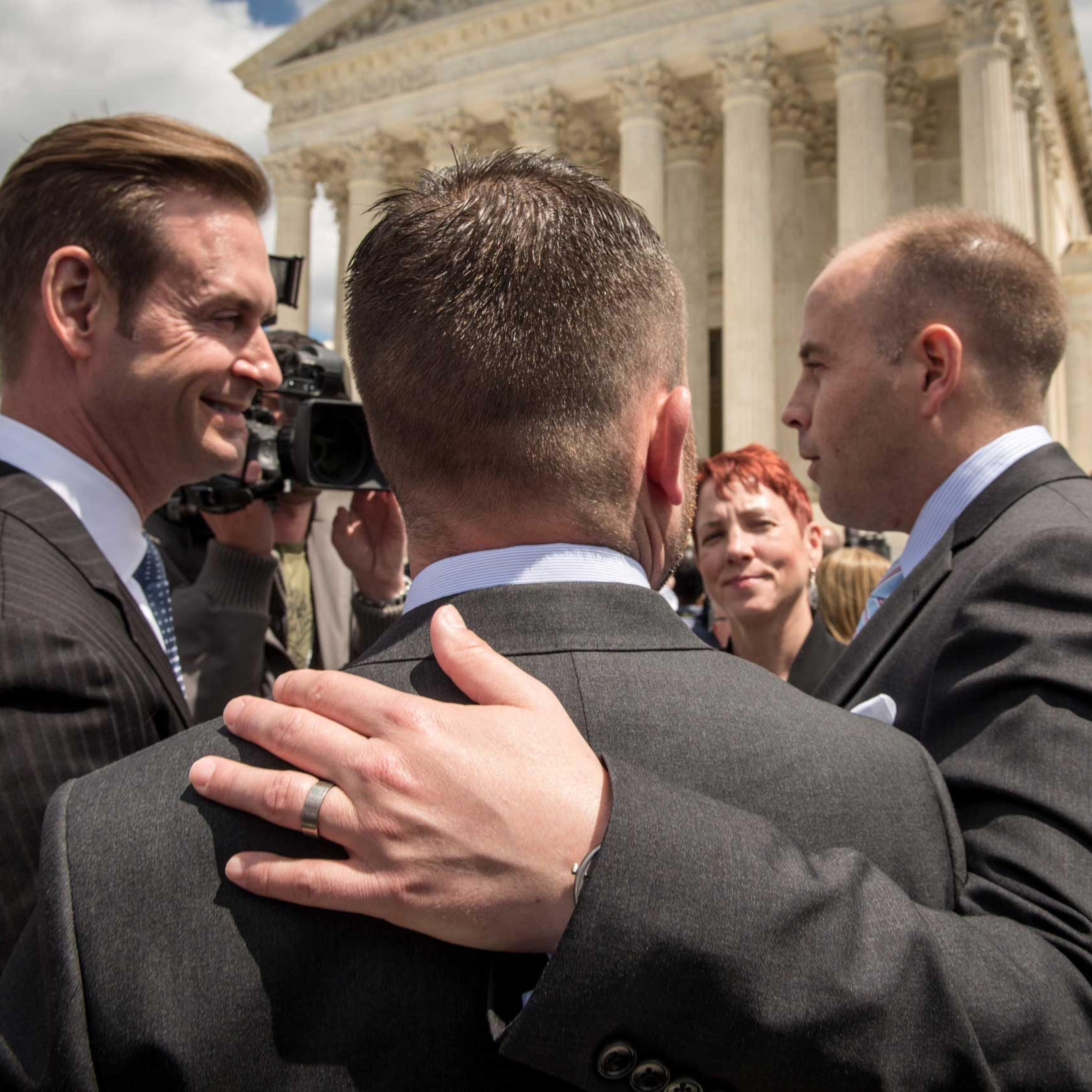Plaintiffs Thomas Kostra, center and his husband Ijpe Dekoe, right, from Tennessee, speak with the media outside the Supreme Court of the United States following arguments on marriage equality in Washington on April 28, 2015.