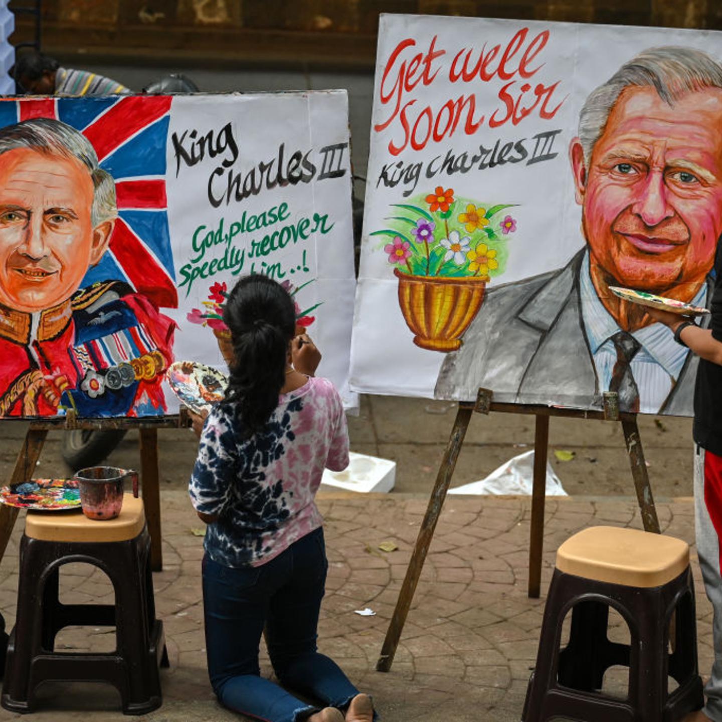 An artist (R) and students give finishing touches to paintings of Britain's King Charles III to wish him a speedy recovery, outside an art school in Mumbai.