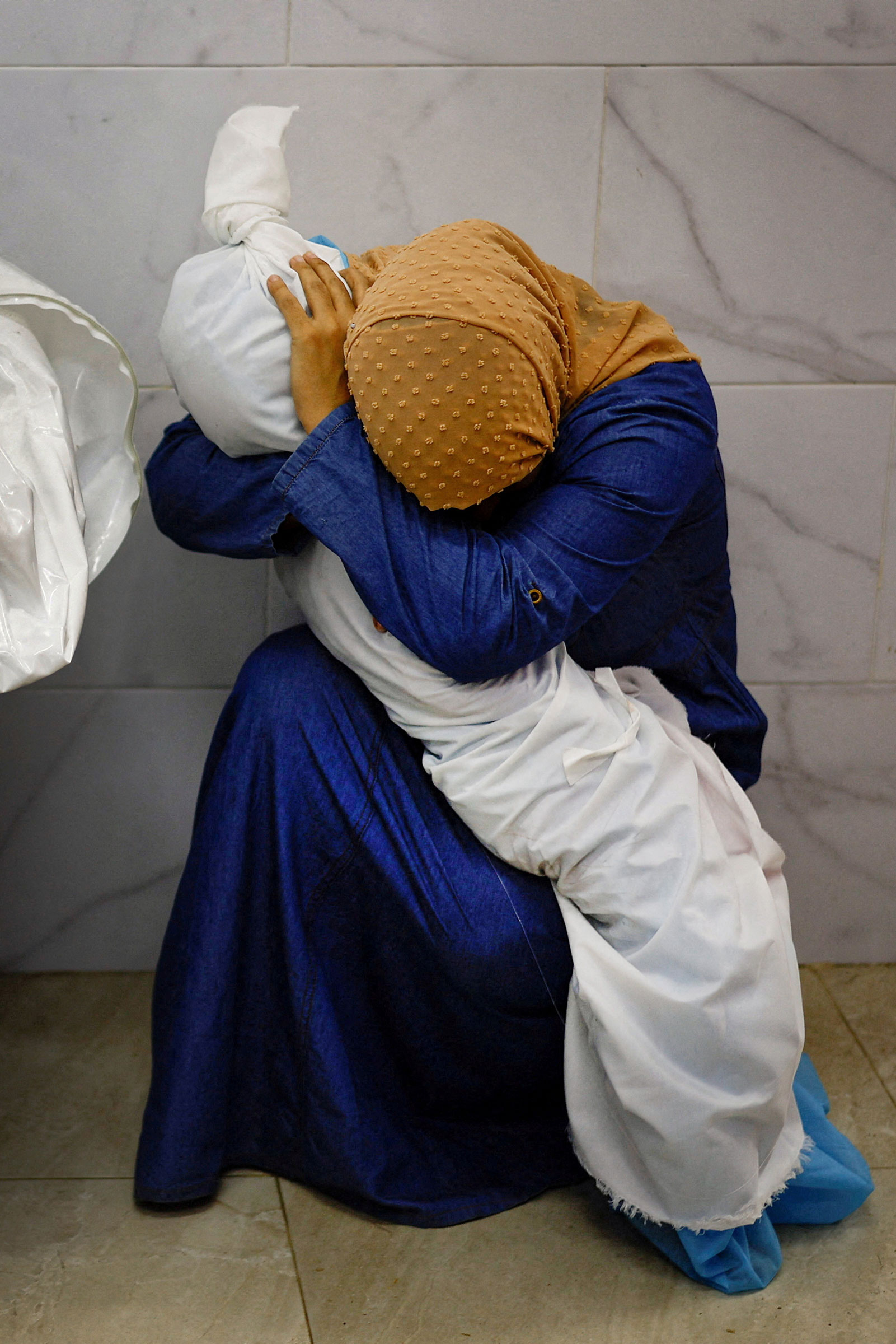 Palestinian woman Inas Abu Maamar, 36, embraces the body of her 5-year-old niece Saly, who was killed in an Israeli strike, at Nasser hospital in Khan Younis in the southern Gaza Strip, on Oct. 17.