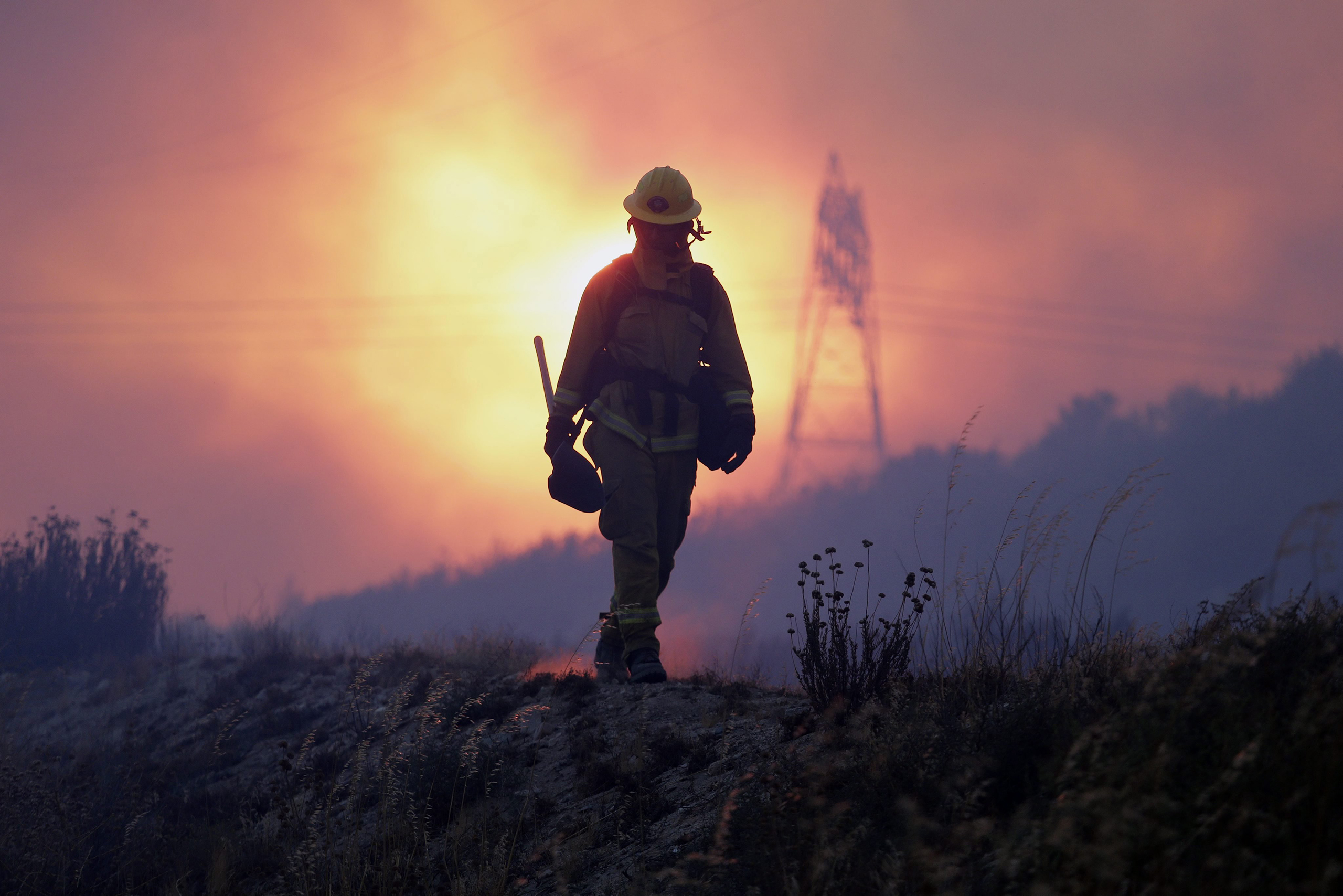 A firefighter keeps an eye on the Blue Cut fire line, north of Los Angeles, Calif, Aug. 16, 2016.