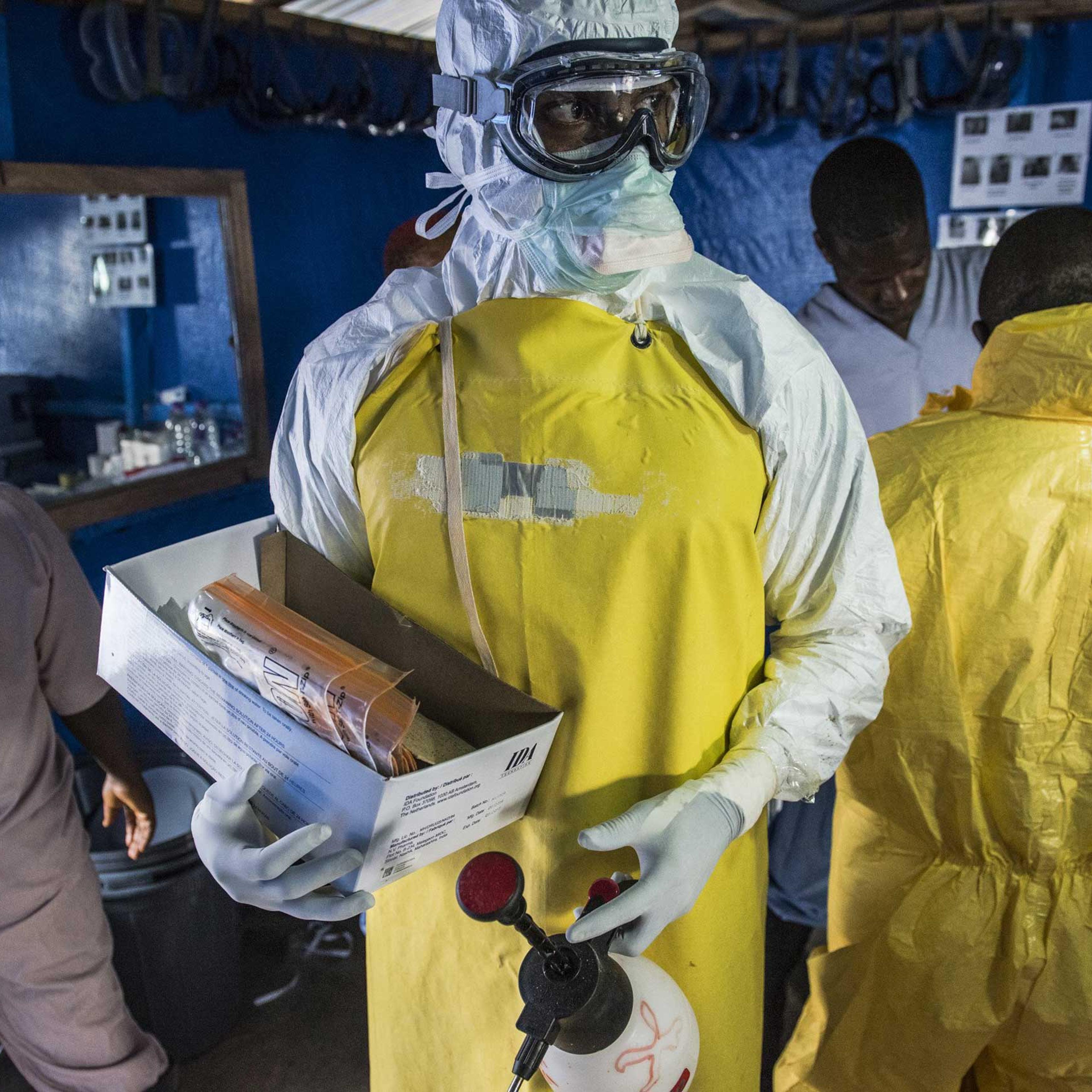 A health worker in protective gear carries empty blood sample kits at the Bong County Ebola treatment center in Suakoko, Liberia, Oct. 19, 2014.