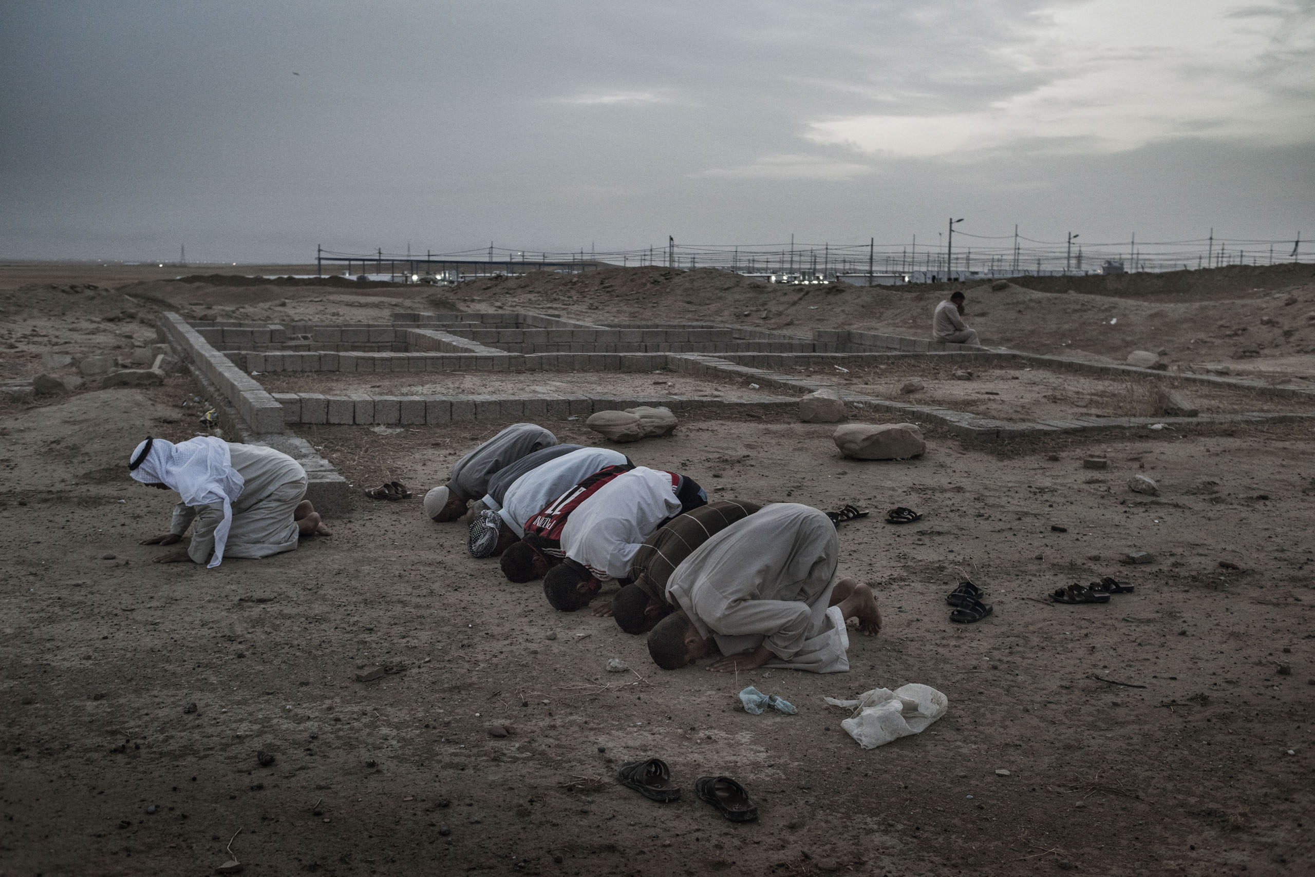 Men pray outside a camp for internally displaced people (IDP's) near the Iraqi town of Makhmour, May 17, 2016. The United Nations said in April that as many as 30,000 people could be forced to flee instability in the Makhmour area, as the Iraqi military 