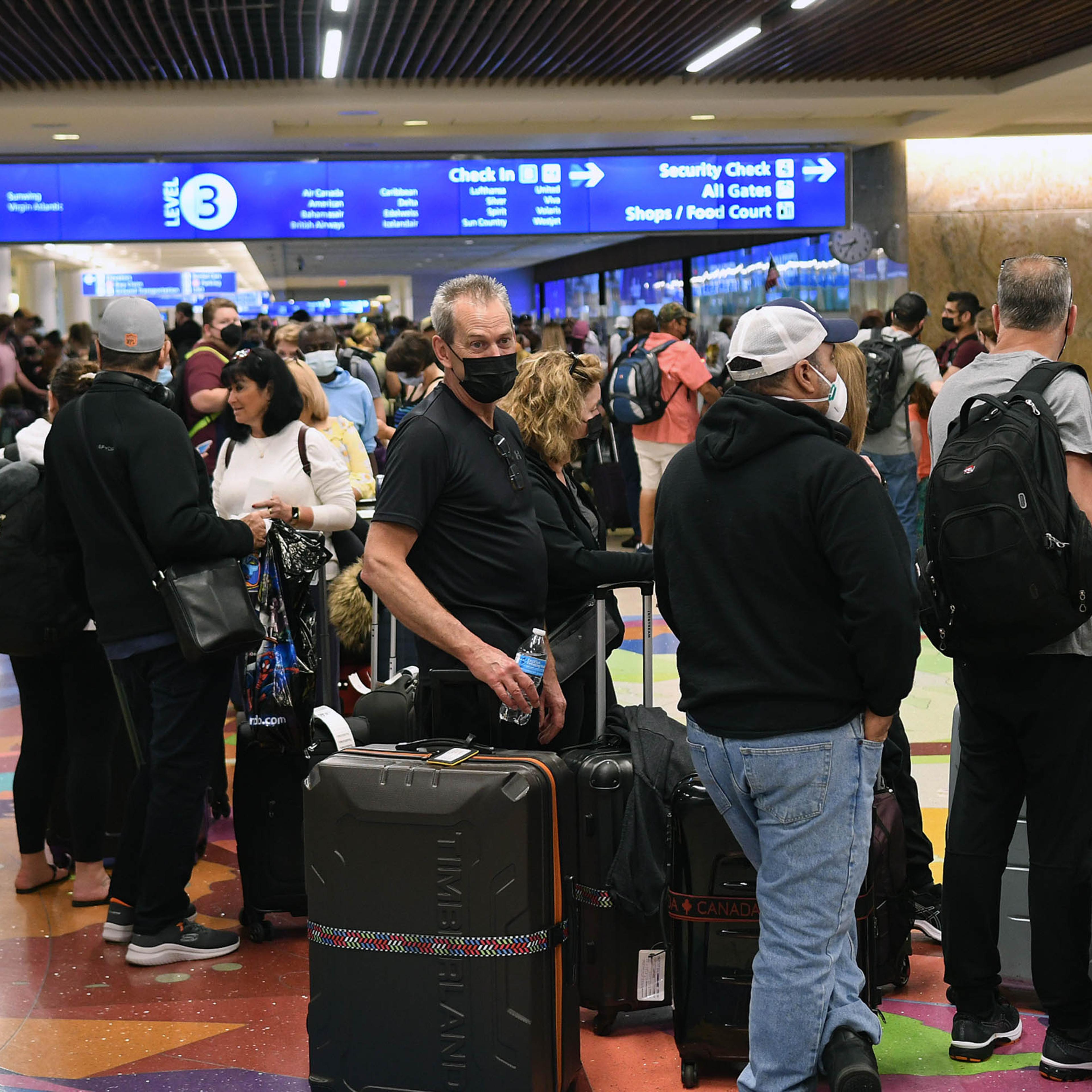 Spring break passengers wait in a TSA security line at