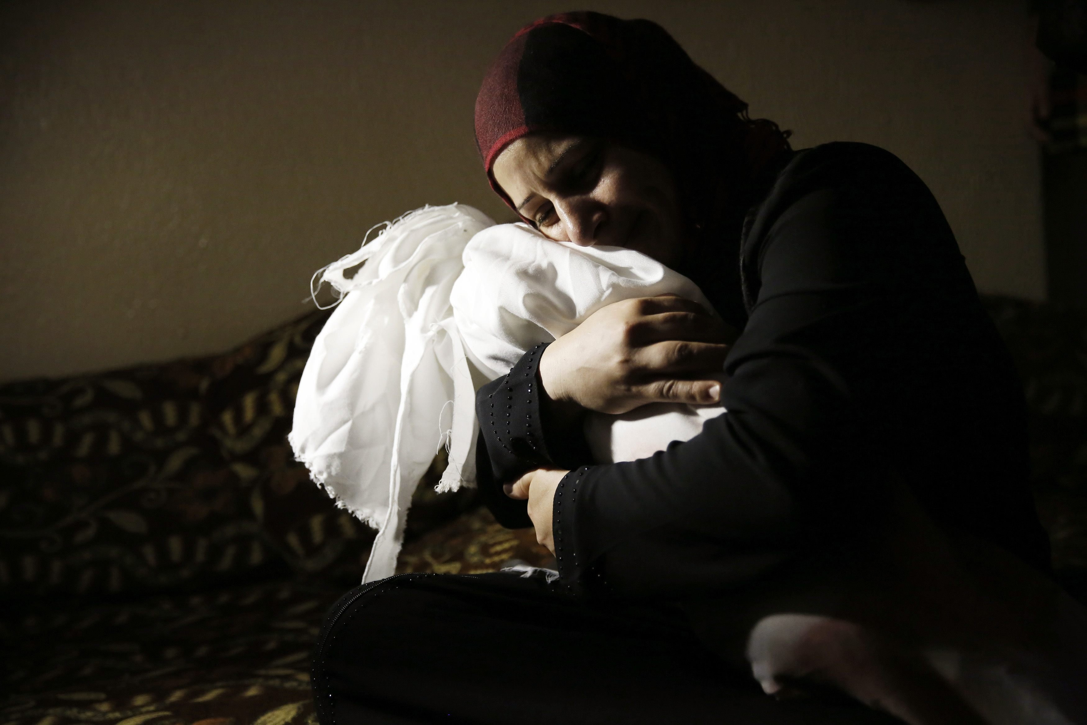 Netream Netzleam holds the body of her daughter Razel, 1, who died in an Israeli air strike on Thursday afternoon, at her funeral in Rafah in the southern Gaza Strip on July 18, 2014.