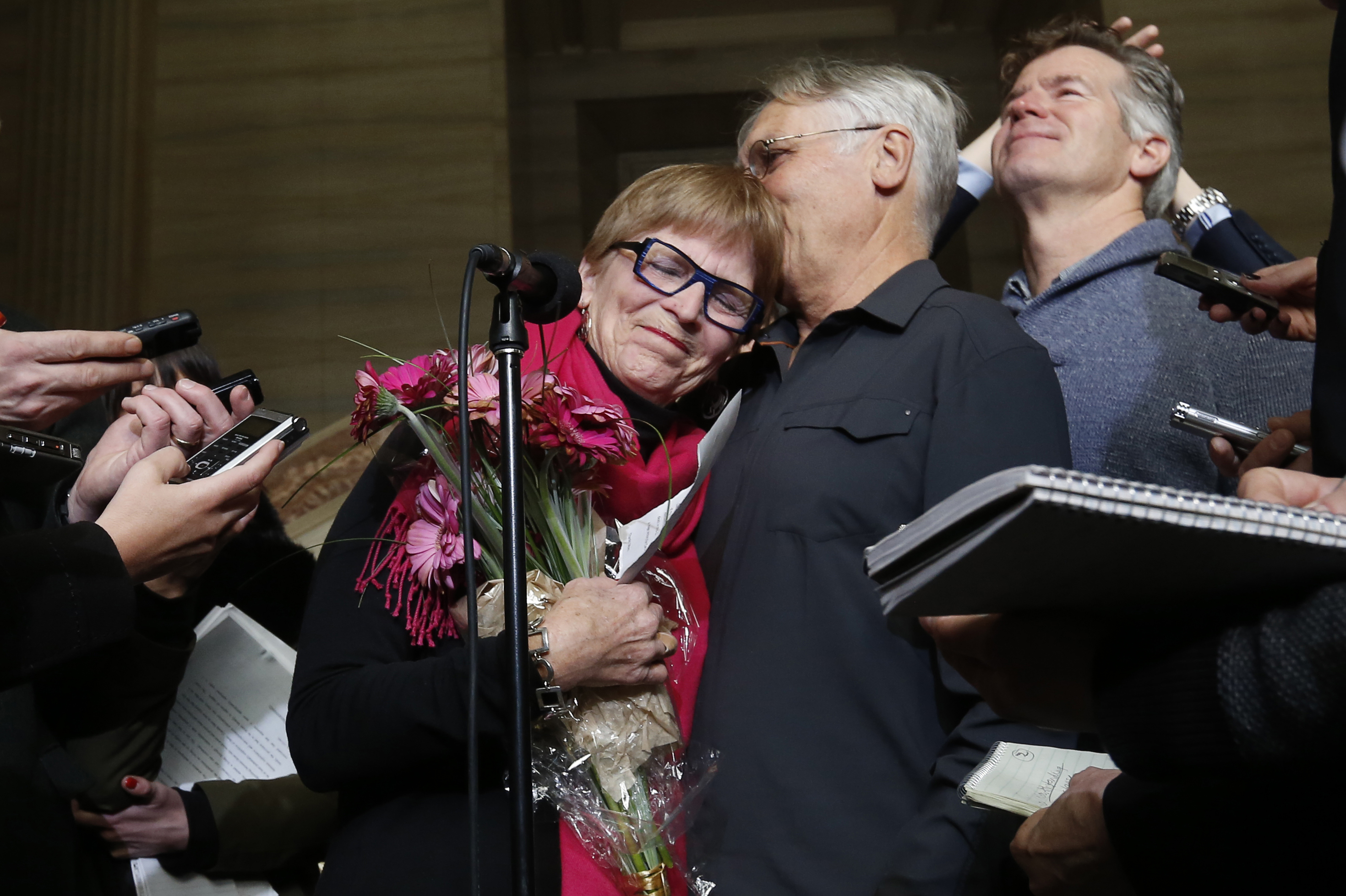 Lee Carter embraces her husband Hollis Johnson while speaking to journalists at the Supreme Court of Canada in Ottawa on Feb. 6, 2015.