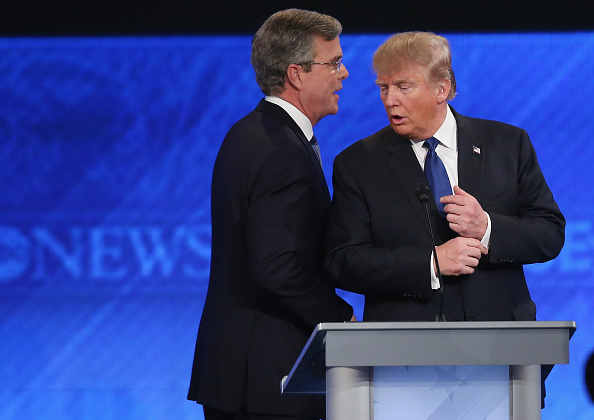 Republican presidential candidates Jeb Bush (L) and Donald Trump talk following the Republican presidential debate at St. Anselm College February 6, 2016 in Manchester, New Hampshire.