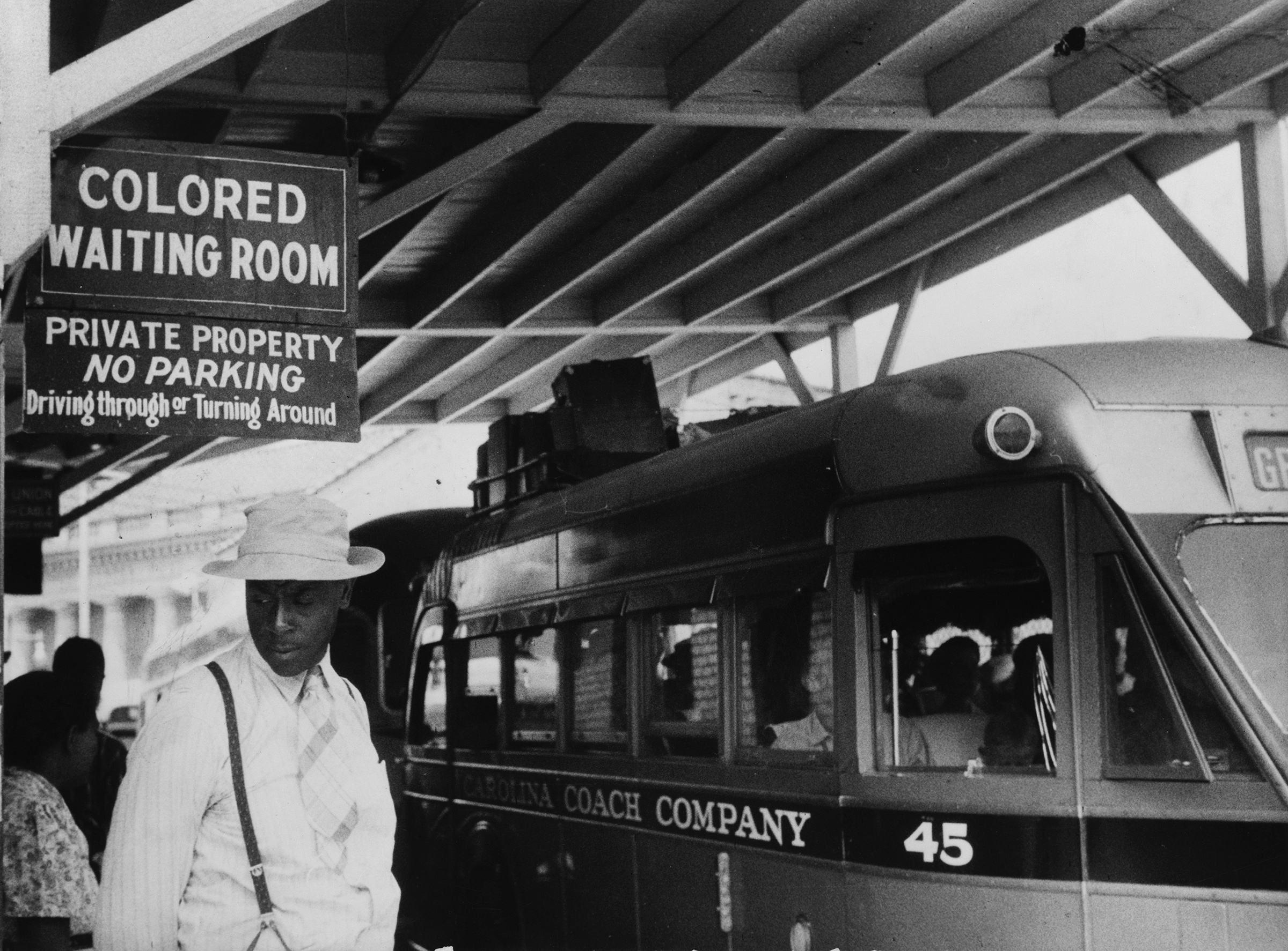 Passengers under a sign that reads “Colored Waiting Room” at a bus station in Durham, N.C., in 1940