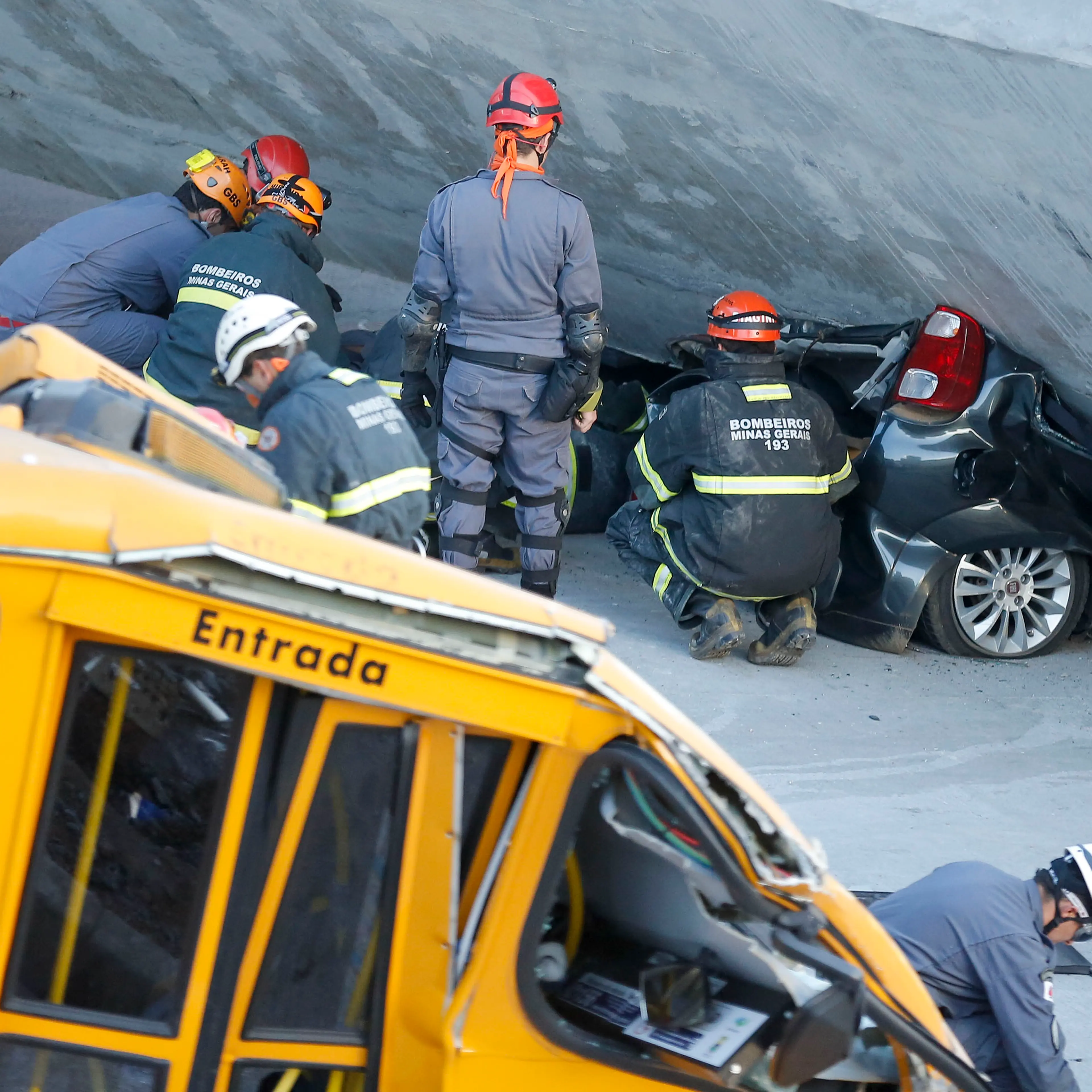 Fire department personnel work to retrieve a car from underneath a collapsed bridge in Belo Horizonte, Brazil, Thursday, July 3, 2014.