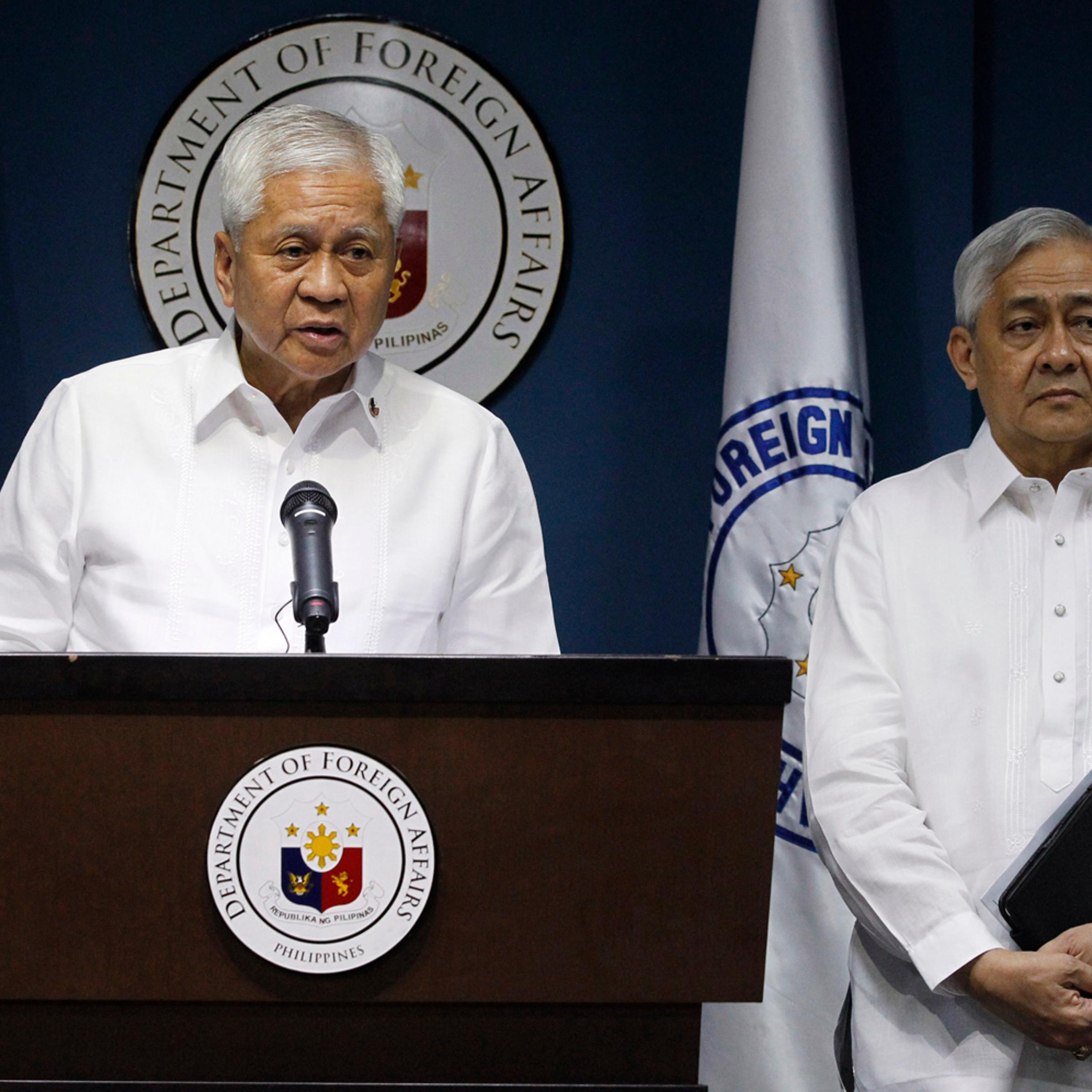 Philippine Foreign Secretary Del Rosario stands next to Solicitor General Jardeleza during a news conference in Manila