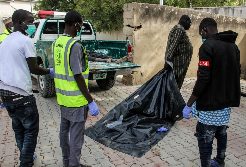 Officials load the body of a victim to the general hospital mortuary