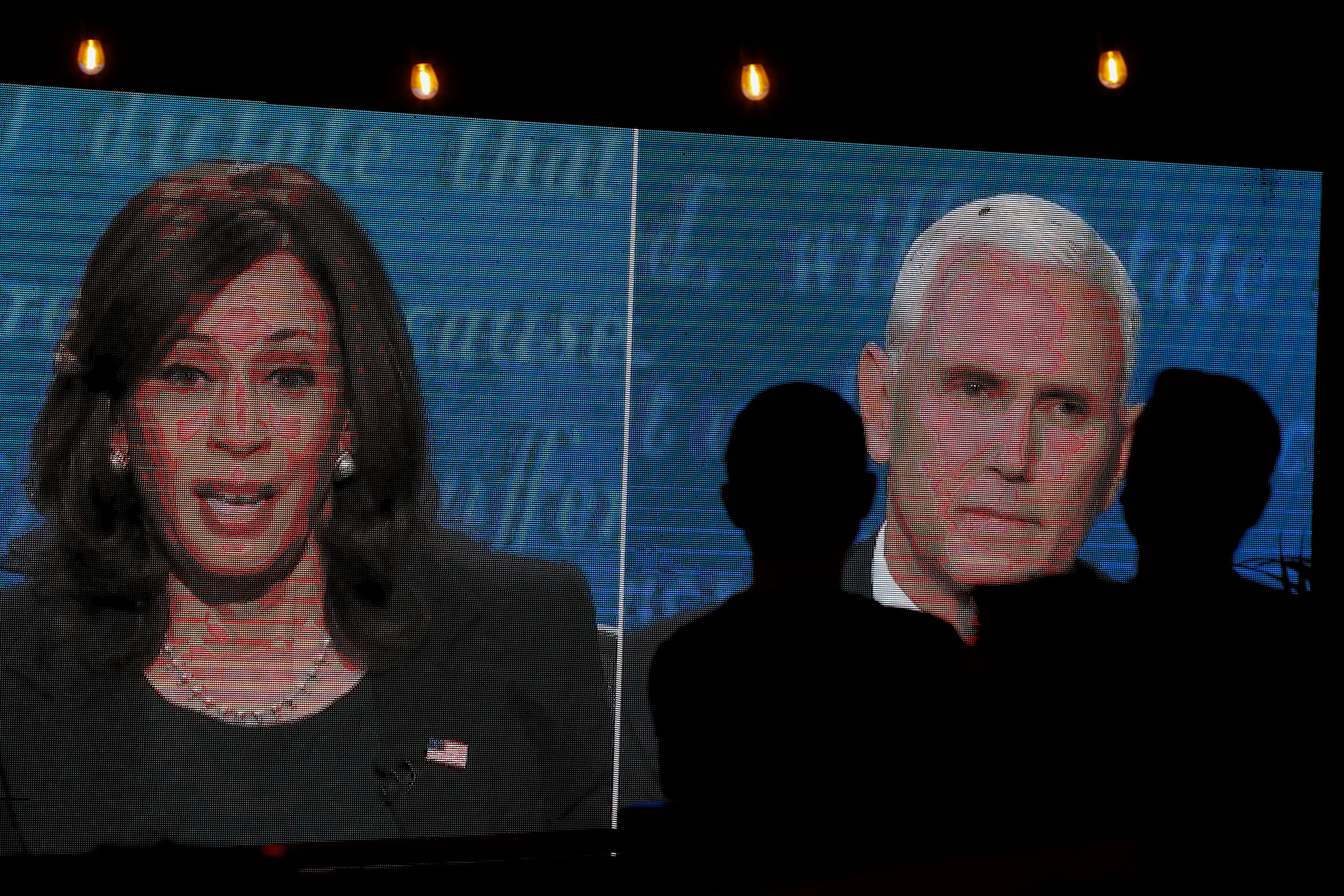 People watch the debate between Vice President Mike Pence and Democratic vice-presidential nominee Sen. Kamala Harris outside a tavern in San Diego, Calif., on Oct. 7, 2020.