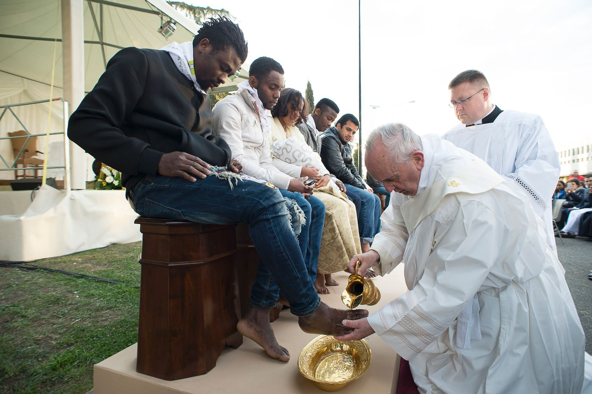 In this handout picture released by the Vatican Press Office, Pope Francis performs the foot-washing ritual at the Castelnuovo di Porto refugees center near Rome, Italy on March 24, 2016. Pope Francis washed the feet of 11 young asylum seekers and a work