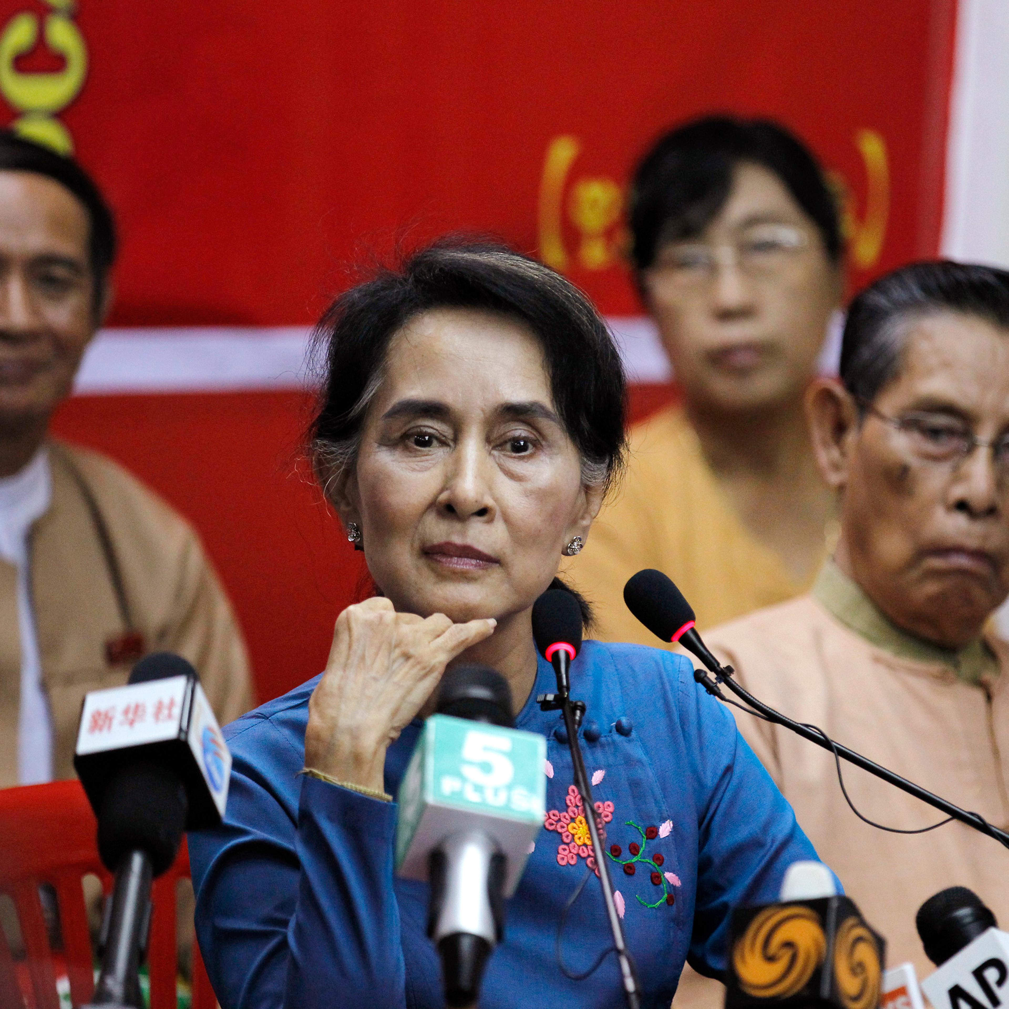 Myanmar's pro-democracy leader Suu Kyi listens as reporter asks her a question during a news conference in Yangon