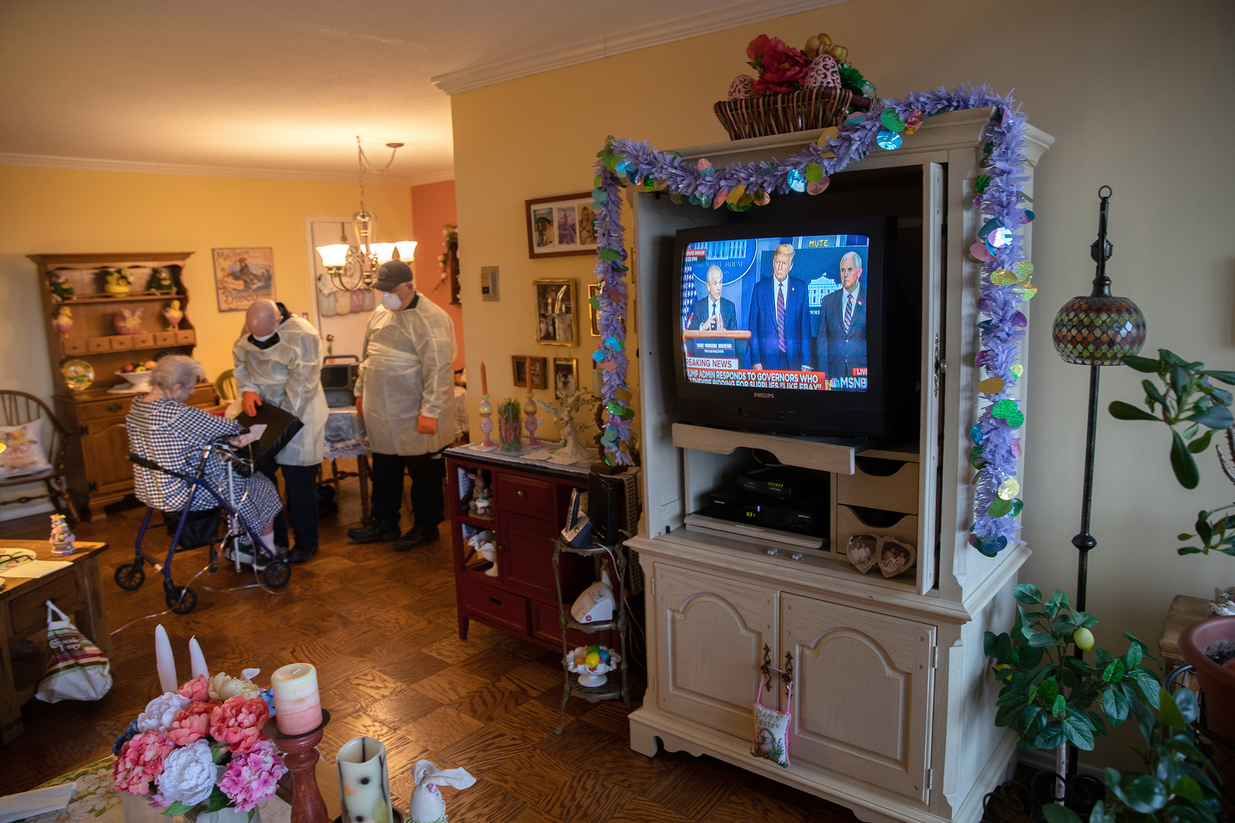 EMS medics wearing personal protective equipment check a woman in her apartment for COVID-19 symptoms during a televised Presidential press conference on April 02 in Stamford, Connecticut. 