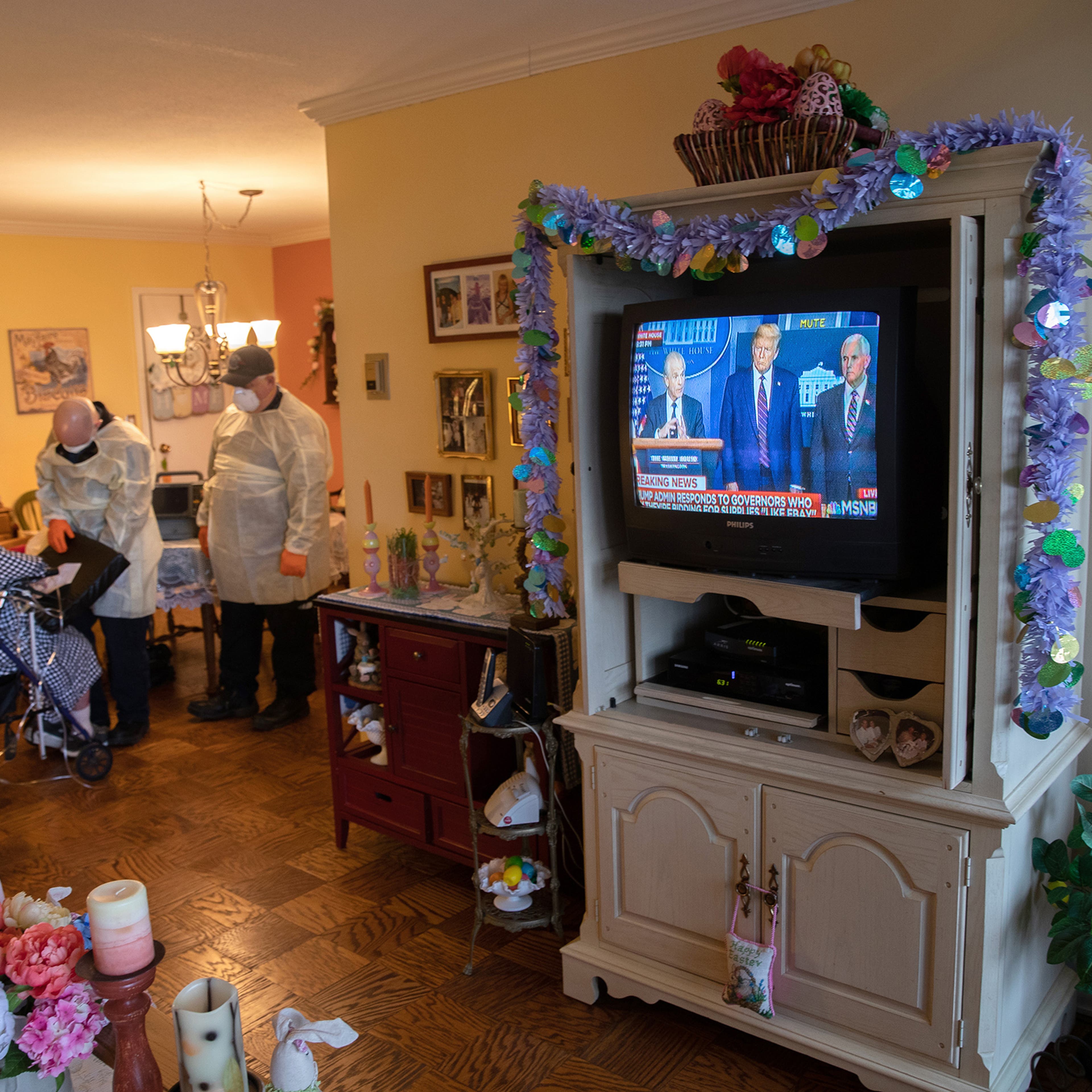 EMS medics wearing personal protective equipment check a woman in her apartment for COVID-19 symptoms during a televised Presidential press conference on April 02 in Stamford, Connecticut.