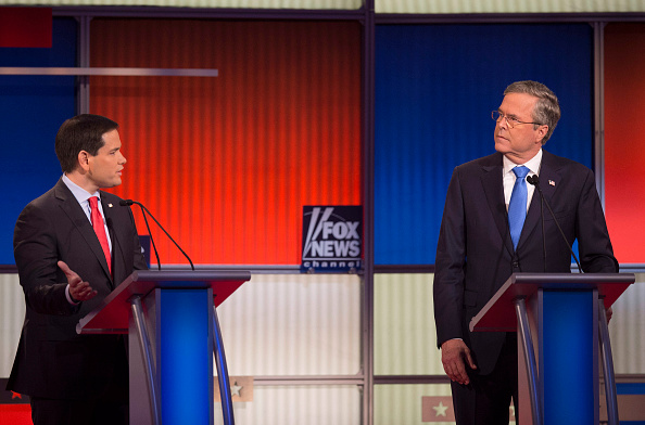 Republican Presidential candidate Florida Senator Marco Rubio (L) speaks as former Florida Gov. Jeb Bush looks on during the Republican Presidential debate sponsored by Fox News at the Iowa Events Center in Des Moines, Iowa on January 28, 2016.