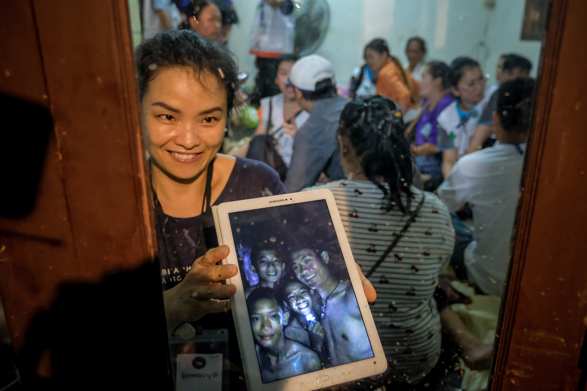 Relatives of the missing boys show photos of them after the 12 boys and their soccer coach have been found alive in the cave where they've been missing for over a week after monsoon rains blocked the main entrance on July 2, 2018 in Chiang Rai, Thailand.