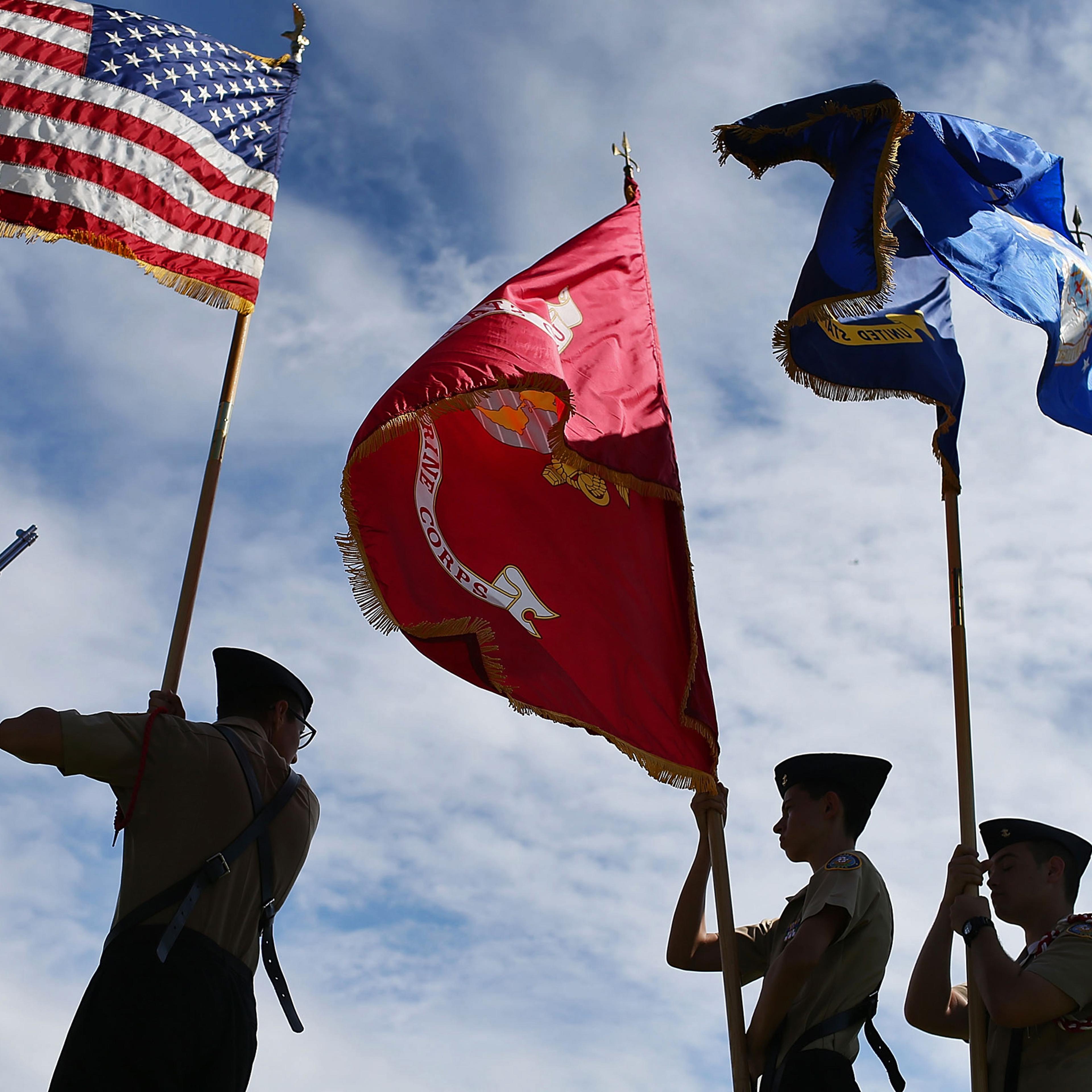 Members of the G. Holmes Braddock Senior High School NJROTC color guard carry their flags during a Veterans day ceremony in Miami Beach, Florida, on Nov. 11, 2015.