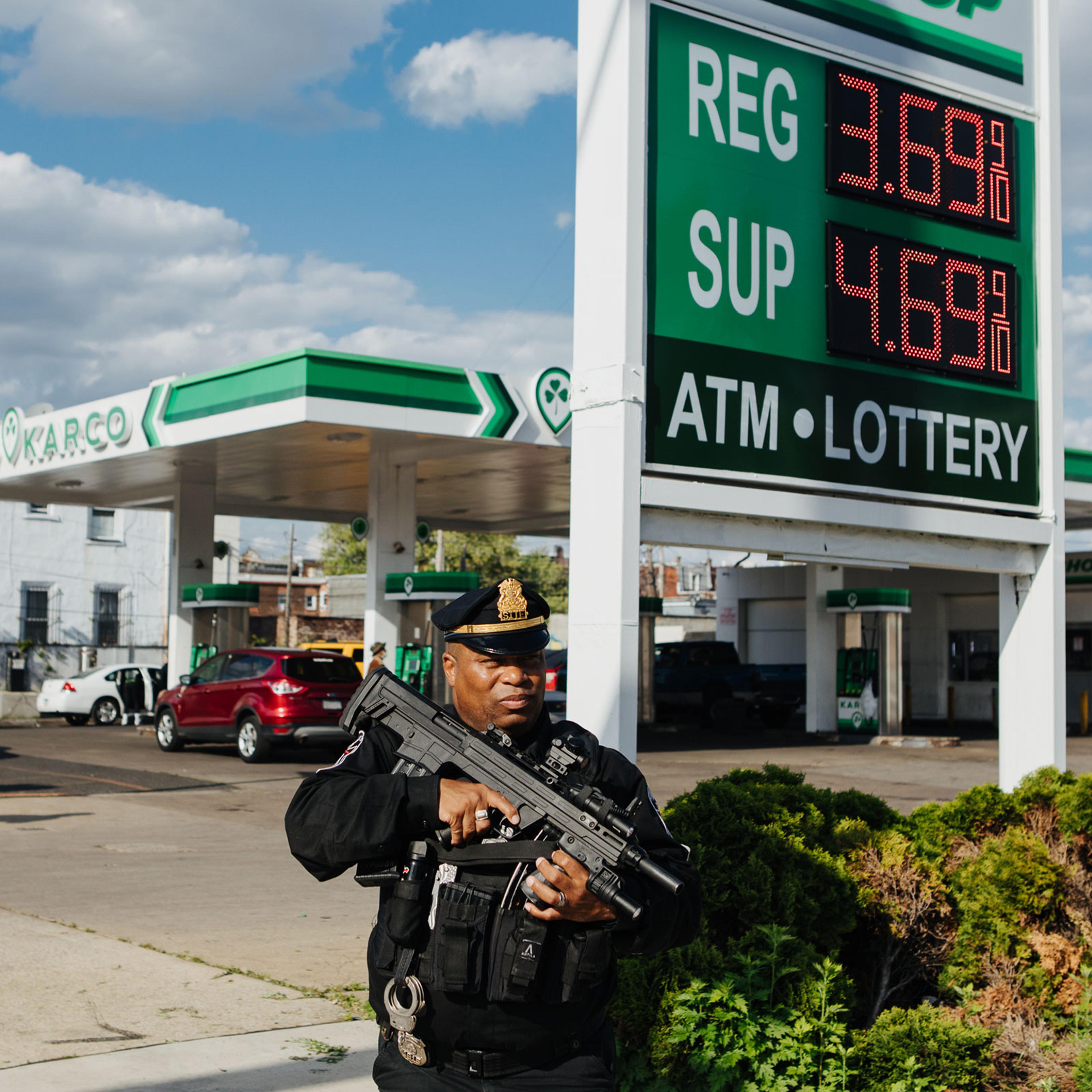 Andre Boyer, an agent for the Strategic Intervention Tactical Enforcement (S.I.T.E.), is seen patrolling the sidewalk outside of a Karco gas station in North Philadelphia, Pa., armed with a Bullpup shotgun, on April 24, 2023.